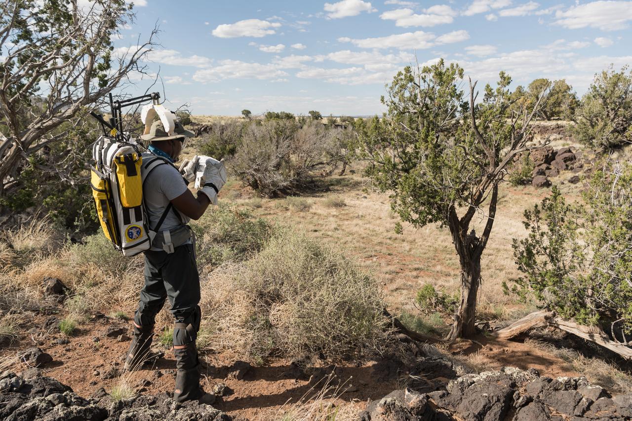 NASA astronaut Andre Douglas takes a picture of the surrounding lunar-like landscape during a simulated moonwalk in the San Francisco Volcanic Field in Northern Arizona on May 17, 2024. Credit: NASA/Josh Valcarcel 