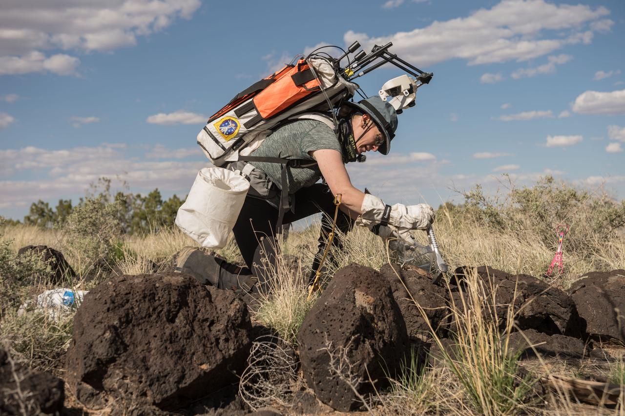 NASA astronaut Kate Rubins uses a chisel to collect a small geologic sample during a simulated moonwalk in the San Francisco Volcanic Field in Northern Arizona on May 17, 2024. Credit: NASA/Josh Valcarcel 