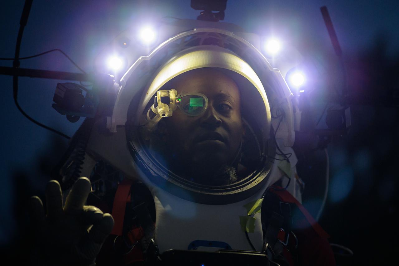 NASA astronaut Andre Douglas wears AR (Augmented Reality) display technology during a nighttime advanced technology run in the San Francisco Volcanic Field in Northern Arizona on May 21, 2024. The monocular lens consists of a pico-projector and waveguide optical element to focus an image for crew to see their real world overlaid with digital information. These unique near-eye form factors may be used to improve the usability and minimally impact the complex biomechanics of working in a pressurized suit environment. Credit: NASA/Josh Valcarcel 
