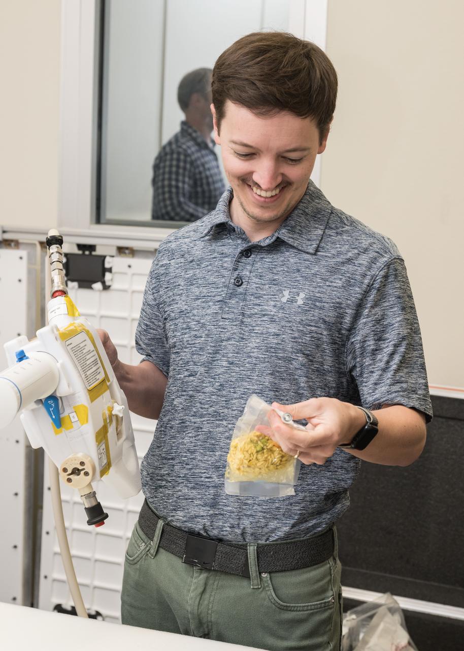 jsc2024e040722 -- Brett Montoya, a lead space architect in the Center for Design and Space Architecture at Johnson Space Center, rehydrates a package of food using the Mini Potable Water Dispenser during a protype testing session at Johnson's Space Center. Photo Credit:  NASA/David DeHoyos