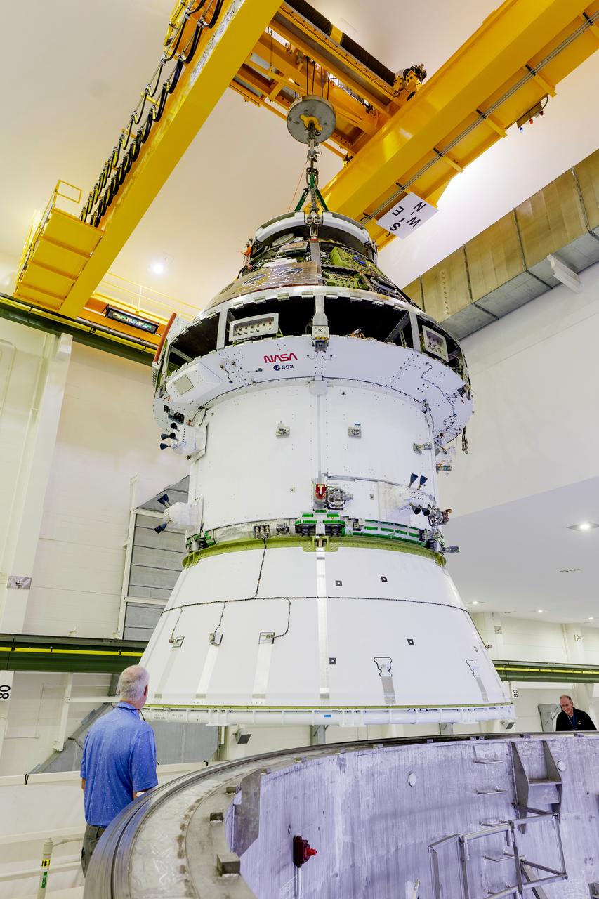 The Artemis II Orion spacecraft is lifted from the Final Assembly and Testing (FAST) Cell and placed in the west altitude chamber inside the Operations and Checkout Building at NASA’S Kennedy Space Center in Florida on June 28, 2024. Inside the altitude chamber, the spacecraft underwent a series of tests simulating deep space vacuum conditions. Photo Credit: NASA / Rad Sinyak 