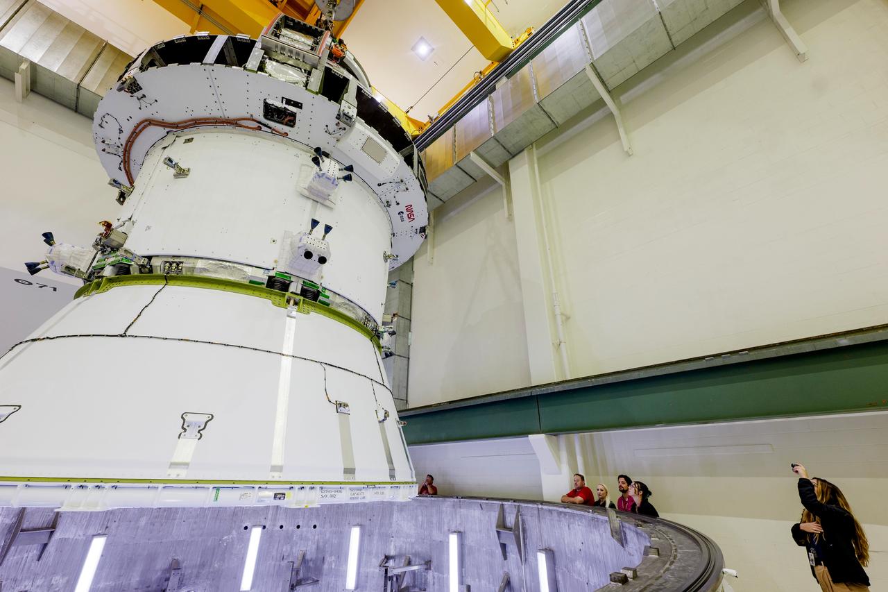 The Artemis II Orion spacecraft is lifted from the Final Assembly and Testing (FAST) Cell and placed in the west altitude chamber inside the Operations and Checkout Building at NASA’S Kennedy Space Center in Florida on June 28, 2024. Inside the altitude chamber, the spacecraft underwent a series of tests simulating deep space vacuum conditions. Photo Credit: NASA / Rad Sinyak 