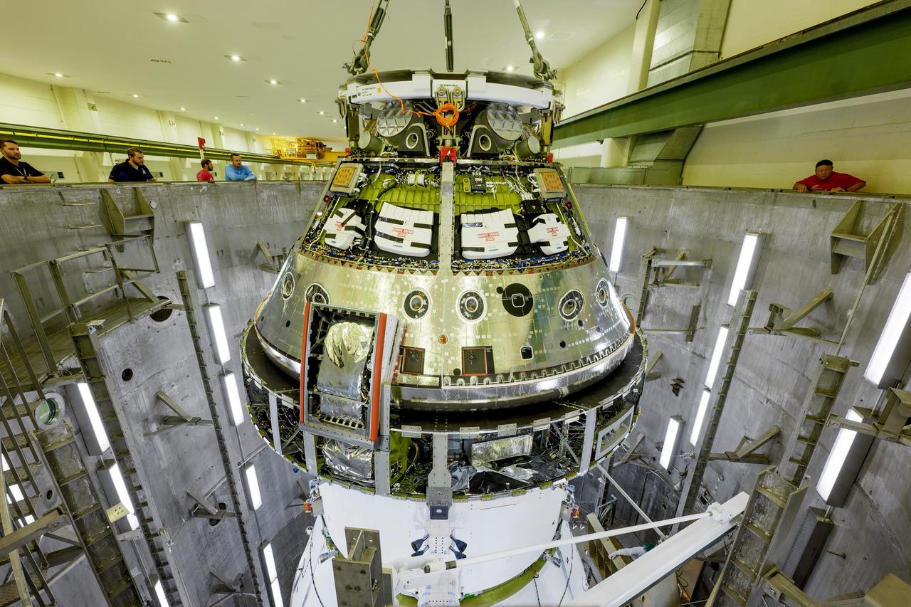 The Artemis II Orion spacecraft is lifted from the Final Assembly and Testing (FAST) Cell and placed in the west altitude chamber inside the Operations and Checkout Building at NASA’S Kennedy Space Center in Florida on June 28, 2024. Inside the altitude chamber, the spacecraft underwent a series of tests simulating deep space vacuum conditions. Photo Credit: NASA / Rad Sinyak 