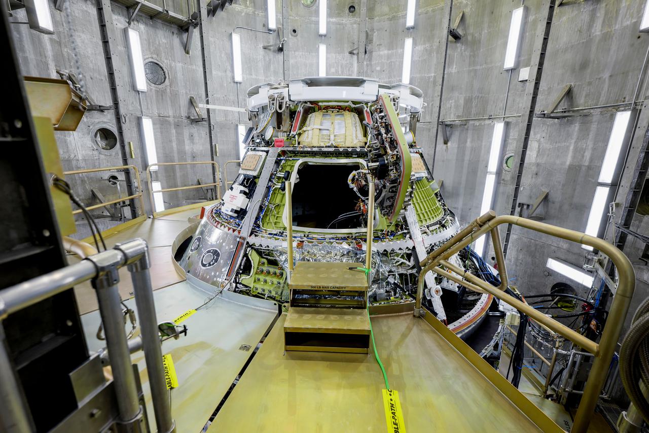 The Artemis II Orion spacecraft is lifted from the Final Assembly and Testing (FAST) Cell and placed in the west altitude chamber inside the Operations and Checkout Building at NASA’S Kennedy Space Center in Florida on June 28, 2024. Inside the altitude chamber, the spacecraft underwent a series of tests simulating deep space vacuum conditions. Photo Credit: NASA / Rad Sinyak 