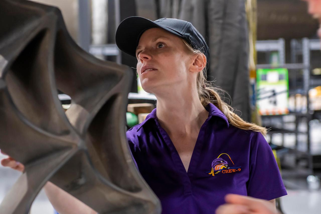 jsc2024e050142 (May 13, 2024) --- NASA’s SpaceX Crew-9 Commander Zena Cardman checks out a grid fin on a Falcon 9 first-stage booster at SpaceX’s HangarX facility at NASA's Kennedy Space Center in Florida. Credit: SpaceX