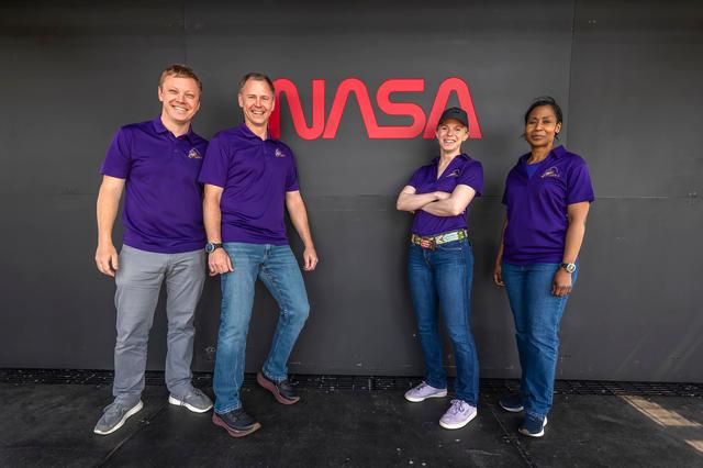 NASA image: NASA's Crew-9 members stand in front of NASA’s worm logo