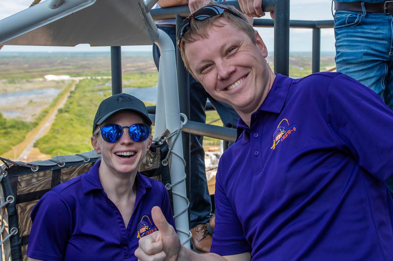 jsc2024e050147 (May 13, 2024) --- SpaceX Crew-9 Commander Zena Cardman from NASA and Mission Specialist Aleksandr Gorbunov from Roscosmos are all smiles from the launch tower at Launch Complex 39A at NASA's Kennedy Space Center in Florida. Credit: SpaceX