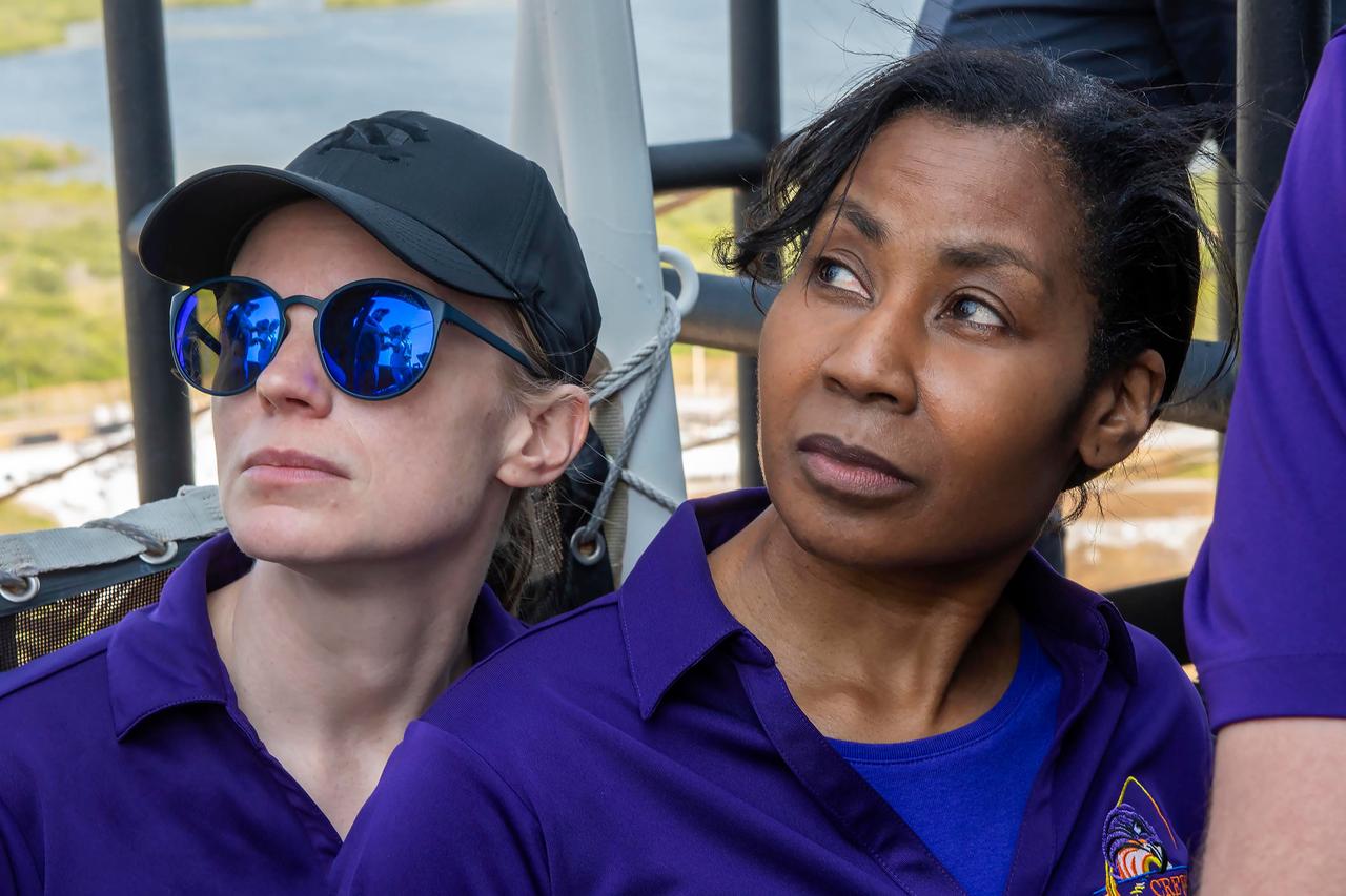 jsc2024e050148 (May 13, 2024) --- From left, NASA’s SpaceX Crew-9 Commander Zena Cardman and Mission Specialist Stephanie Wilson look off into the distance from the launch tower at Launch Complex 39A at NASA's Kennedy Space Center in Florida. Credit: SpaceX