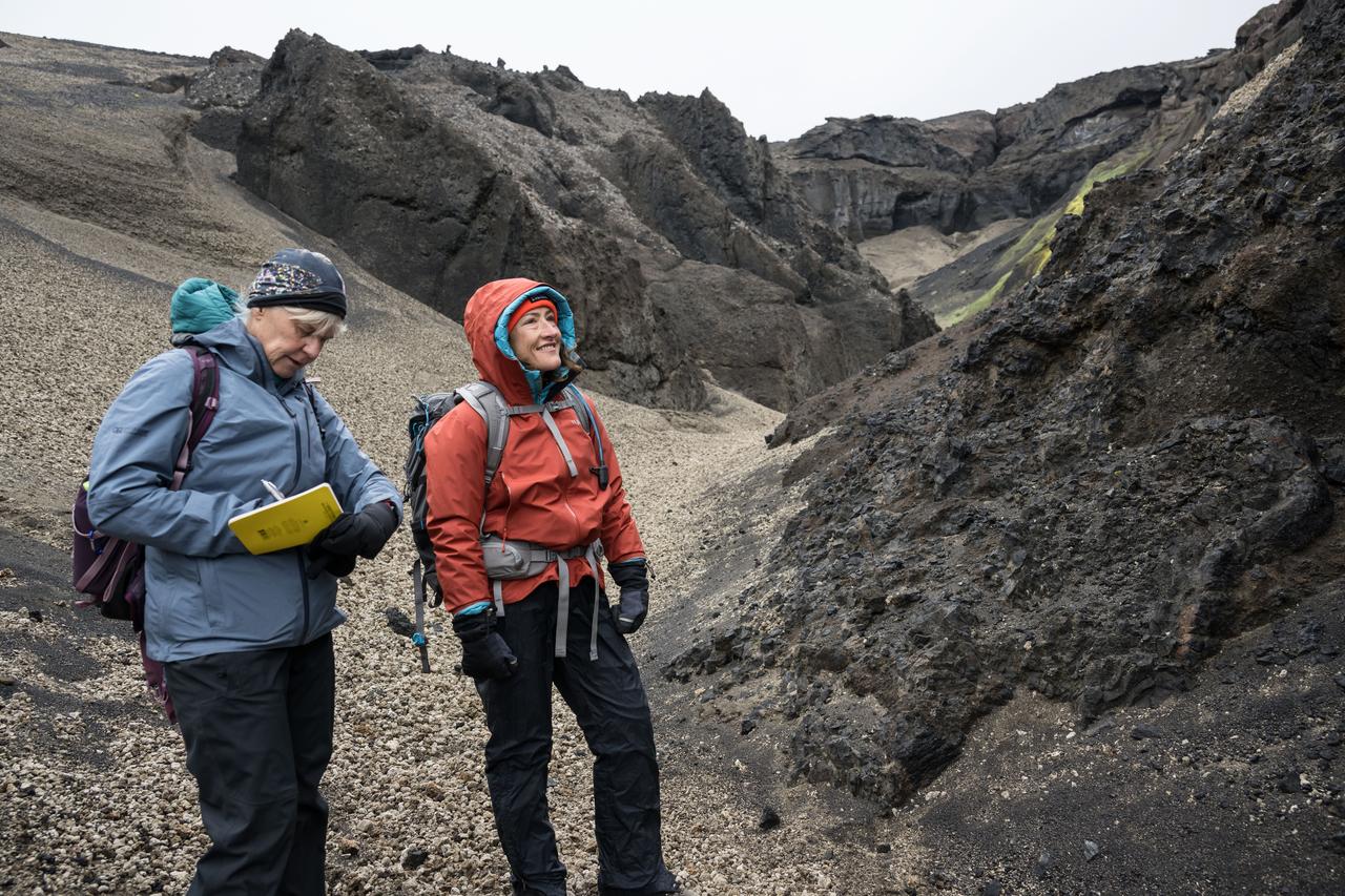 Artemis geology training lead at NASA's Johnson Space Center in Houston, Cindy Evans (left) and NASA astronaut and Artemis II mission specialist Christina Koch study geologic features in Iceland during Artemis II crew geology training in August 2024. 