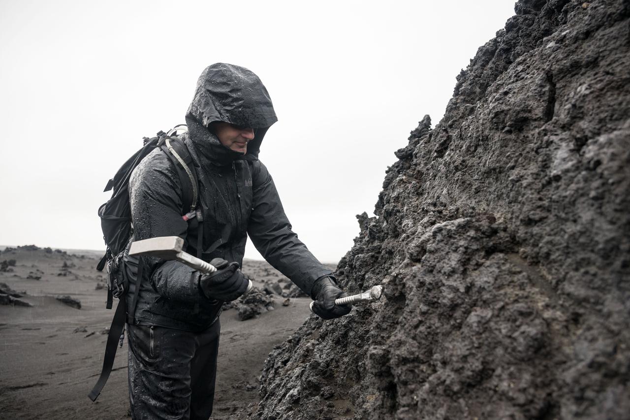 CSA (Canadian Space Agency) astronaut and Artemis II crew member Jeremy Hansen uses a rock hammer and chisel to break a sample off a large boulder during a geology field training exercise in Iceland. 