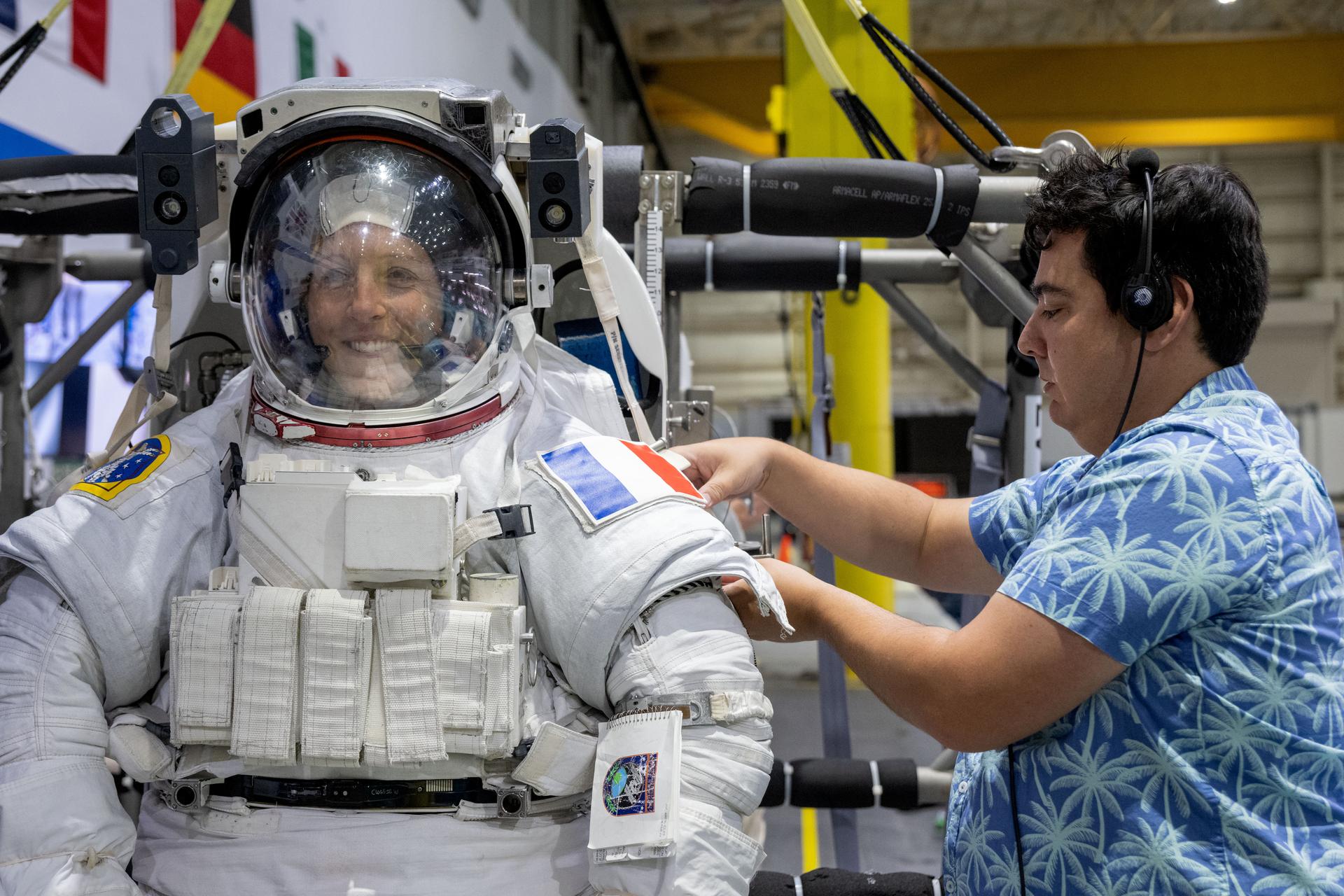 ESA (European Space Agency) astronaut Sophie Adenot is assisted by support personnel in her spacesuit during a spacewalk training session at Johnson Space Center's Neutral Buoyancy Laboratory in Houston, Texas.