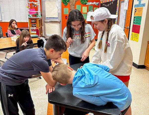 jsc2024e067103 (2/2/2024) --- Martha and Josh Morris Mathematics and Engineering Elementary students Lizzy, Lynnley, Isaac, and Cooper work on ways to calculate the strength of concrete in microgravity. Their experiment, Will Normal Strength Concrete (NSC) Keep its Structure in Microgravity?, is part of the Nanoracks-National Center for Earth and Space Science Education-Surveyor-Student Spaceflight Experiments Program Mission 18 to ISS (Nanoracks-NCESSE-Surveyor-SSEP).