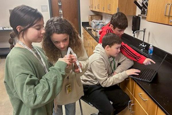 jsc2024e067104 (10/15/2024) --- Robbie E. Howard Junior High School student researchers (Cadee Smith, Coralee Holloway, Caiden Holmquist, and Levi Blaise Lewis) take measurements and record data for their experiment, How do microgravity and space conditions affect the growth of Cucumber, Cucumbis sativus? Their experiment is part of the Nanoracks-National Center for Earth and Space Science Education-Surveyor-Student Spaceflight Experiments Program Mission 18 to ISS (Nanoracks-NCESSE-Surveyor-SSEP).