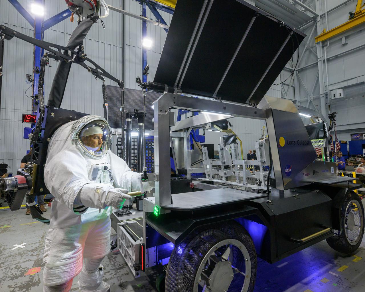 NASA astronaut Joe Acaba raises the solar array panel on Lunar Outpost’s Eagle lunar terrain vehicle during testing at NASA’s Johnson Space Center. Image Credit: NASA/Robert Markowitz