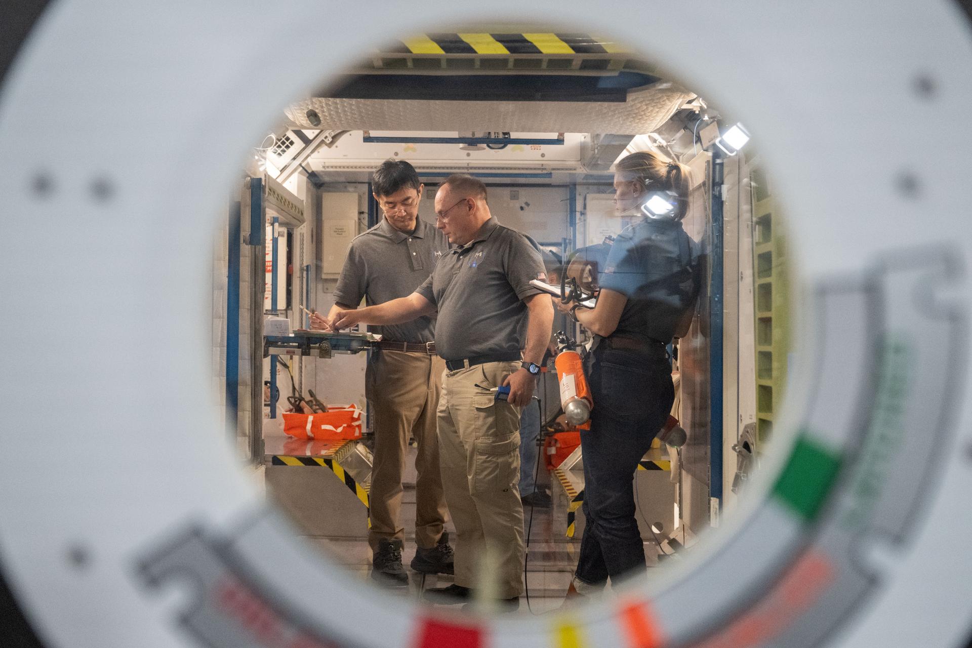 From left to right: JAXA astronaut Kimiya Yui, NASA astronaut Mike Fincke, and NASA astronaut Zena Cardman conduct training for the unlikely event of an emergency at the Space Vehicle Mockup Facility at NASA’s Johnson Space Center in Houston, Texas.