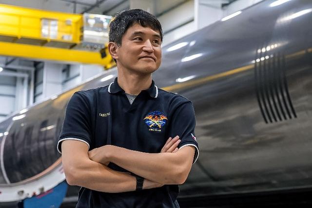 jsc2024e080749 (Dec. 13, 2024) --- NASA’s SpaceX Crew-10 Mission Specialist Takuya Onishi of JAXA (Japan Aerospace Exploration Agency), stands in front of a Falcon 9 first-stage booster at SpaceX’s HangarX facility at NASA's Kennedy Space Center in Florida. Credit: SpaceX