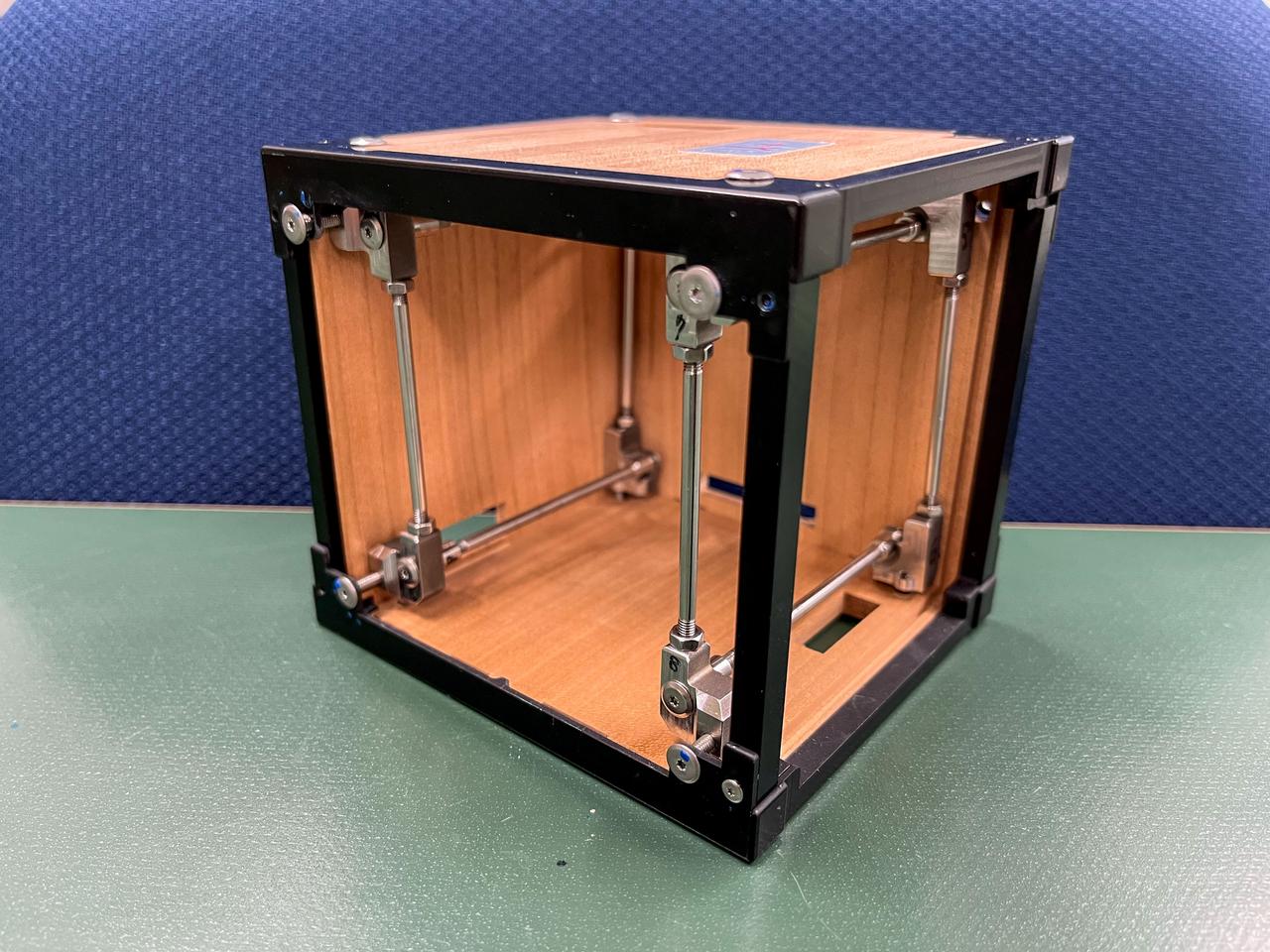 jsc2024e081749 (3/18/2023) --- LignoSat structural internal view shows the relationship among wooden panels, aluminum frames, and stainless steel shafts. LignoSat is the world’s first wooden satellite and investigates how wood changes in the space environment, as well as how wood transmits data through geomagnetic fields and wood’s resistance to cosmic radiation. Image courtesy of Kyoto University.