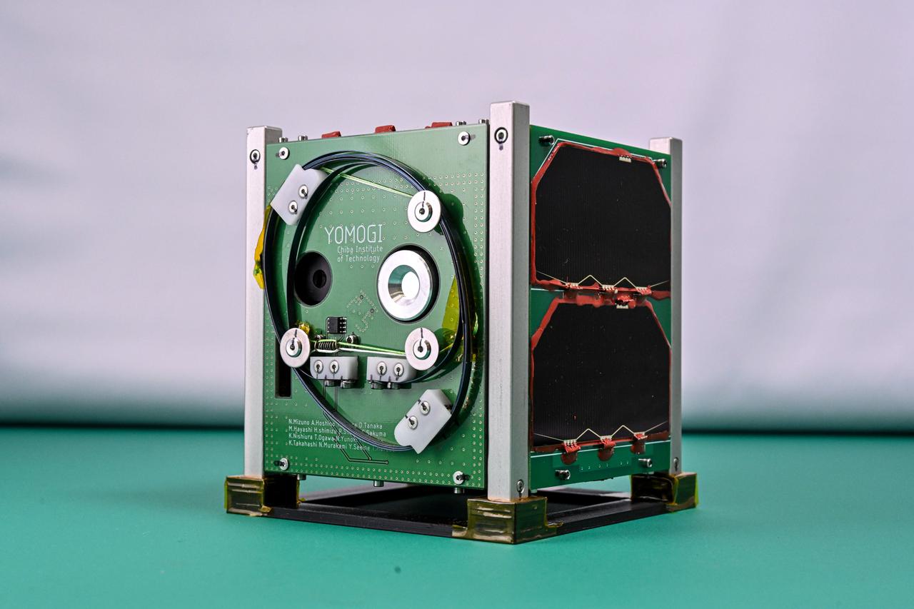 jsc2025e000005 (11/8/2023) --- Shown is the Growing Advanced and Refined space Development ENgineering succession and under the satellite - YOMOGI (GARDENs – YOMOGI) flight unit. YOMOGI is an 1kg 1U CubeSat, developed as part of the GARDENs Project from the Chiba Institute of Technology. The goal of the YOMOGI mission is to send and receive sensor data from ground stations using the APRS (Automatic Packet Reporting System), and to demonstrate observations the capability to make Earth observations of Tokyo Bay and water sources in Uganda. Image courtesy of Chiba Institute of Technology.