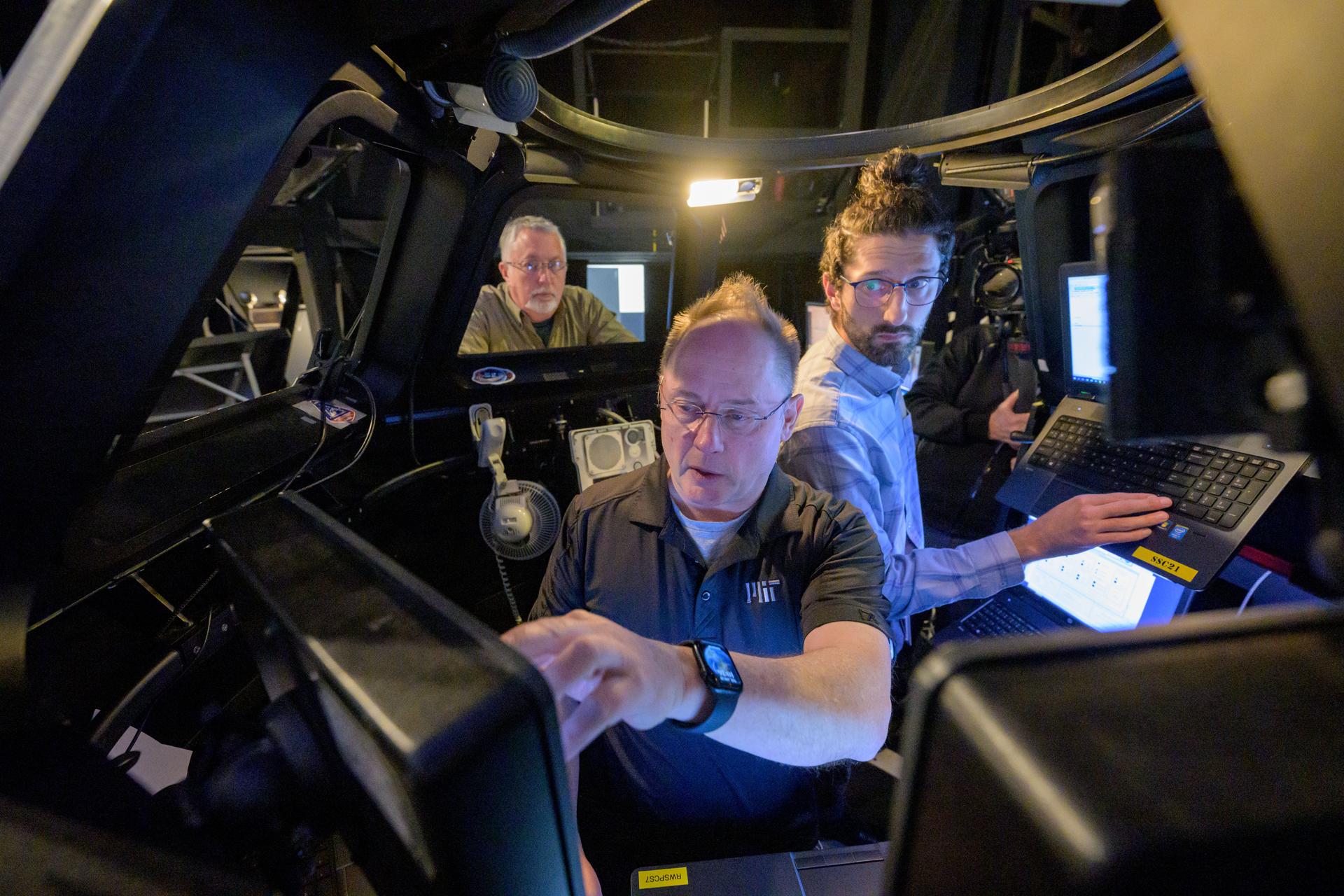 NASA astronaut Mike Fincke (center) works with his trainers in a simulator to brush up on berthing Sierra Space’s Dream Chaser and other space station robotics skills at NASA’s Johnson Space Center in Houston, Texas.