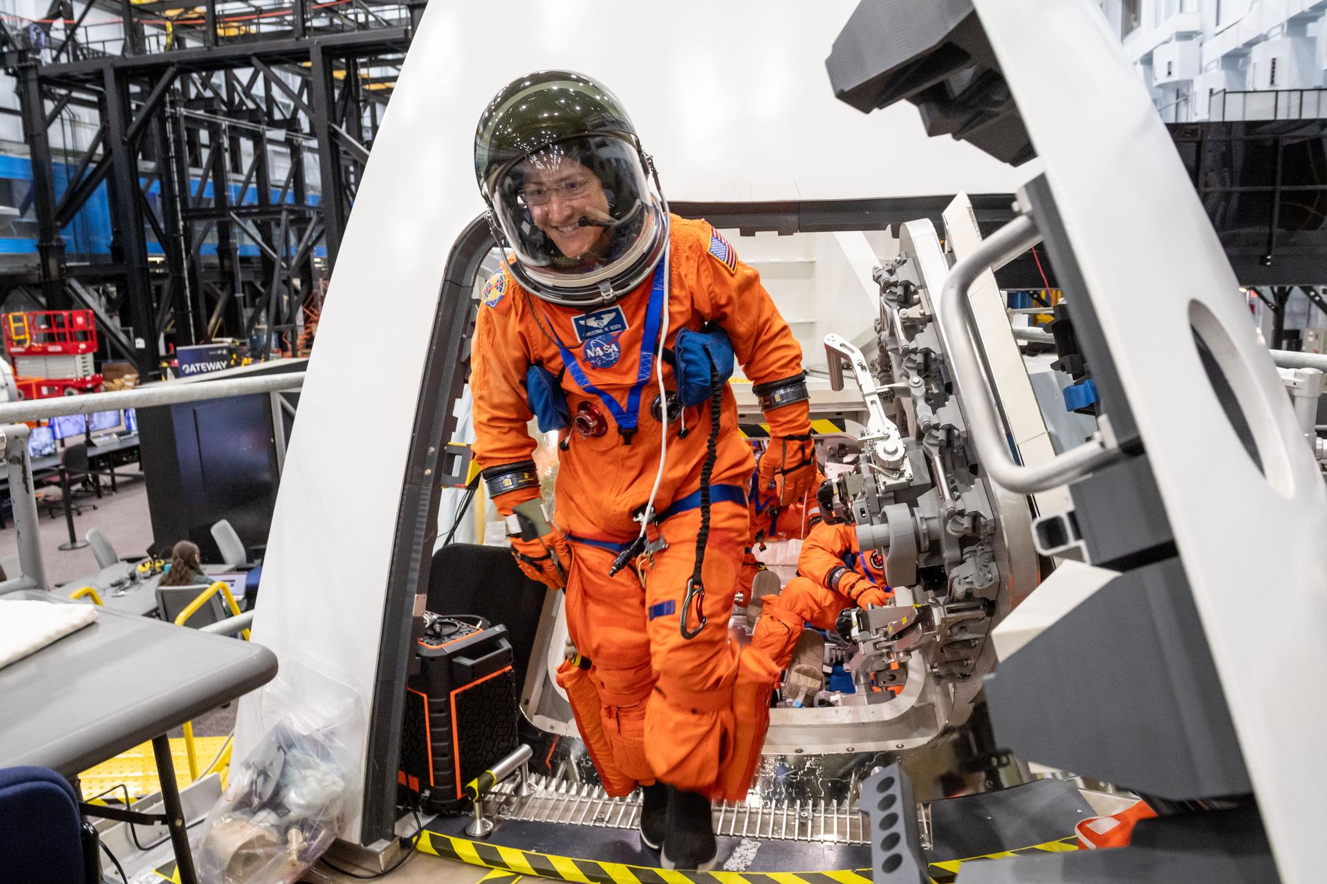 NASA astronaut and Artemis II mission specialist Christina Koch exits the Orion spacecraft mockup during Post Insertion and Deorbit Preparation training at the Space Vehicle Mockup Facility in Houston, Texas. The crew practiced getting the Orion spacecraft configured once in orbit, how to make it habitable, and suited up in their entry pressure suits to prepare for their return from the Moon