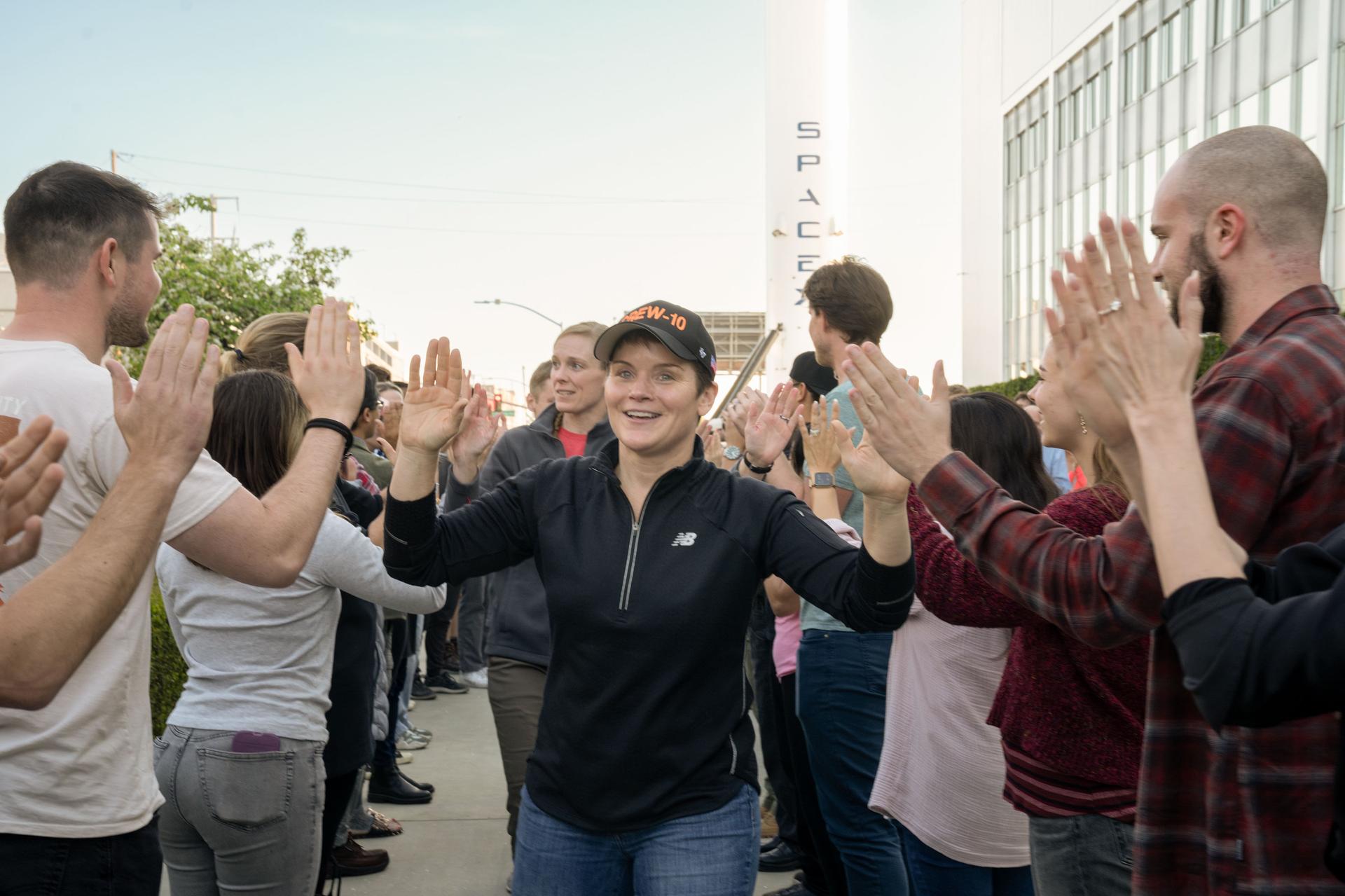NASA astronaut and commander of NASA's SpaceX Crew-10 mission Anne McClain smiles and high fives SpaceX employees during a sendoff at the company’s facility in Hawthorne, California.