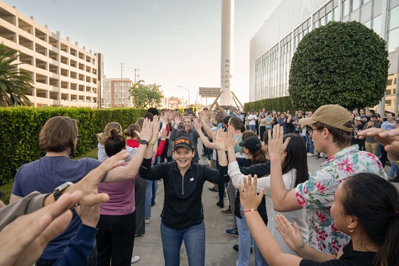 NASA astronaut and commander of NASA's SpaceX Crew-10 mission Anne McClain smiles and high fives SpaceX employees during a sendoff at the company’s facility in Hawthorne, California.