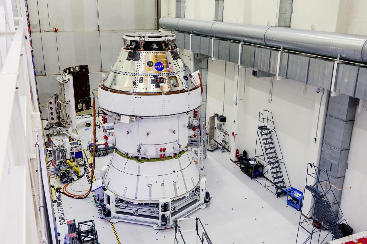 Date: 2/27/2025 Photographer: NASA/Rad Sinyak Caption: Technicians begin working on the installation of the four solar array wings for NASA’s Artemis II Orion spacecraft inside the Operations and Checkout Building at NASA’s Kennedy Space Center on Feb. 27, 2025. Artemis II is Orion’s first crewed flight test around the Moon under the agency’s Artemis campaign.  