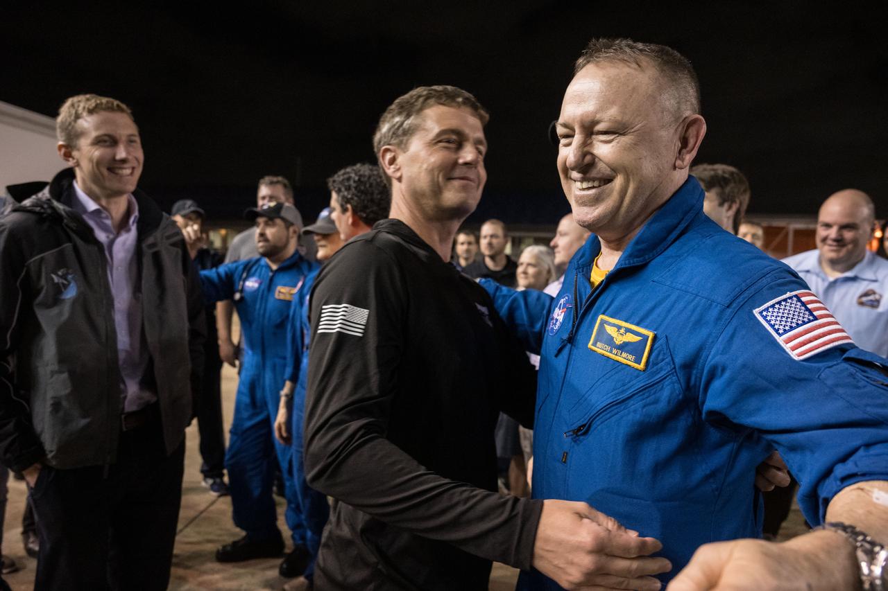 jsc2025e032543 (March 18, 2025) --- NASA astronaut Butch Wilmore receives a warm welcome at Johnson Space Center's Ellington Field in Houston from NASA astronauts Reid Wiseman and Woody Hoburg after completing a long-duration science mission aboard the International Space Station. After undocking from the orbiting laboratory, NASA’s SpaceX Crew-9 splashed down at 5:57 p.m. EDT on Tuesday, March 18, in the Gulf of America near Tallahassee, Florida.