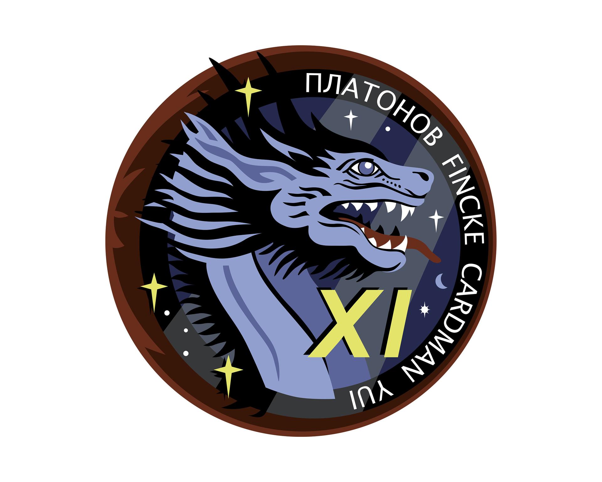 The Crew-11 mission patch embodies teamwork, exploration, and the deep connections that bind us—across nations, agencies, and families. Shades of white, red, and blue pay tribute to the flags of the three nations represented by the crew, while three gold stars symbolize the unity of our three space agencies working together in pursuit of discovery. .At the heart of the design, two radiant sunbeams form the number “11” illuminating a blue circle—a subtle nod to Voyager’s Pale Blue Dot image, reminding us of the fragile unity of our shared home. This vision of Earth is reflected in the dragon’s eye, reinforcing our focus on exploration and the perspective gained from space. .The dragon, evoking the heraldry of family crests, stands as a guardian of our mission and legacy. Within the stars, we honor the children of the crew, a reminder of the generations inspired by human spaceflight. Encircling it all, a red flame represents both the power of launch and the plasma of reentry, symbolizing the full journey—our departure from Earth, our work aboard the International Space Station, and our safe return home. Crew-11: Together, we rise.