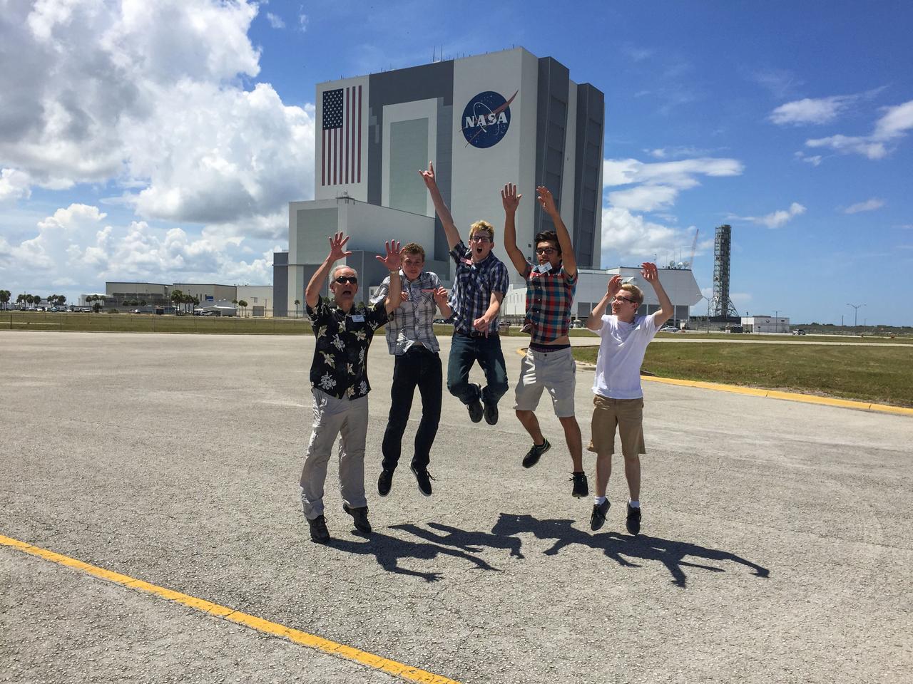 jsc2025e044834 (7/16/2016) --- The NanoRacks-Crystallization Of Silver Nitrate in Microgravity On a Silver Cathode (NanoRacks-COSMOS) research team from Eaglecrest High School in Centennial, Colorado is photographed at Kennedy Space Center on July 18, 2016. This investigation assesses the 3D structure of silver nitrate crystals formed by electrolysis in microgravity. From Left: Dave Schlichting, Gavin Morgenneg, Scott Crowner, Lars Drieth, Ben Sheffer. Image courtesy of Dave Schlichting.