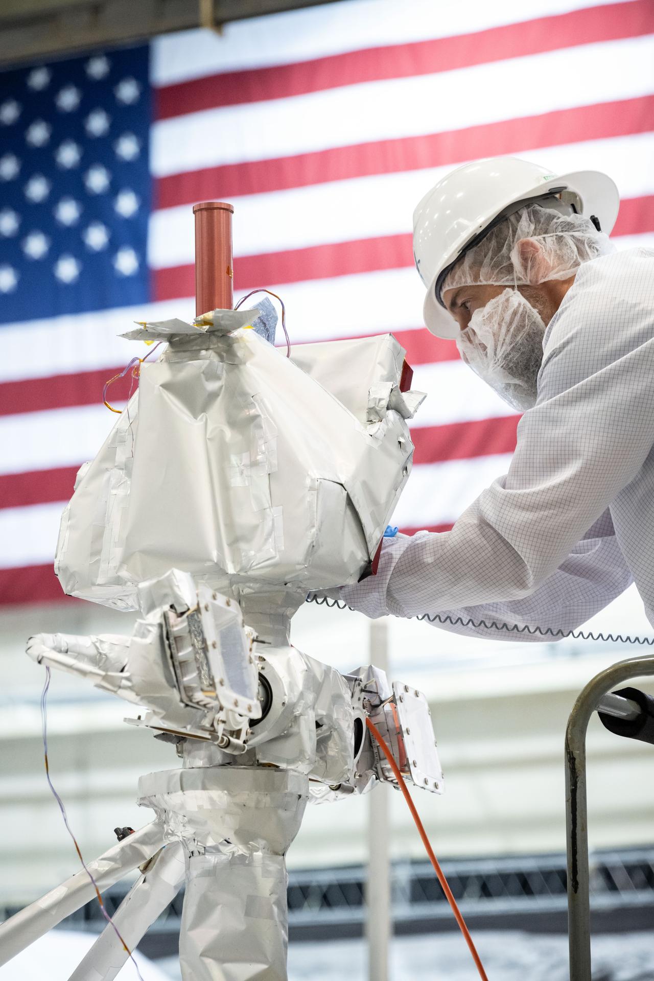 jsc2025e064263 - VIPER Vehicle Manager Justin Ridley connects a cable to the VIPER high gain antenna while preparing the rover for long-term storage testing in the high bay of Building 9S at Johnson Space Center.  Photographer: Helen Arase Vargas – Johnson Space Center 
