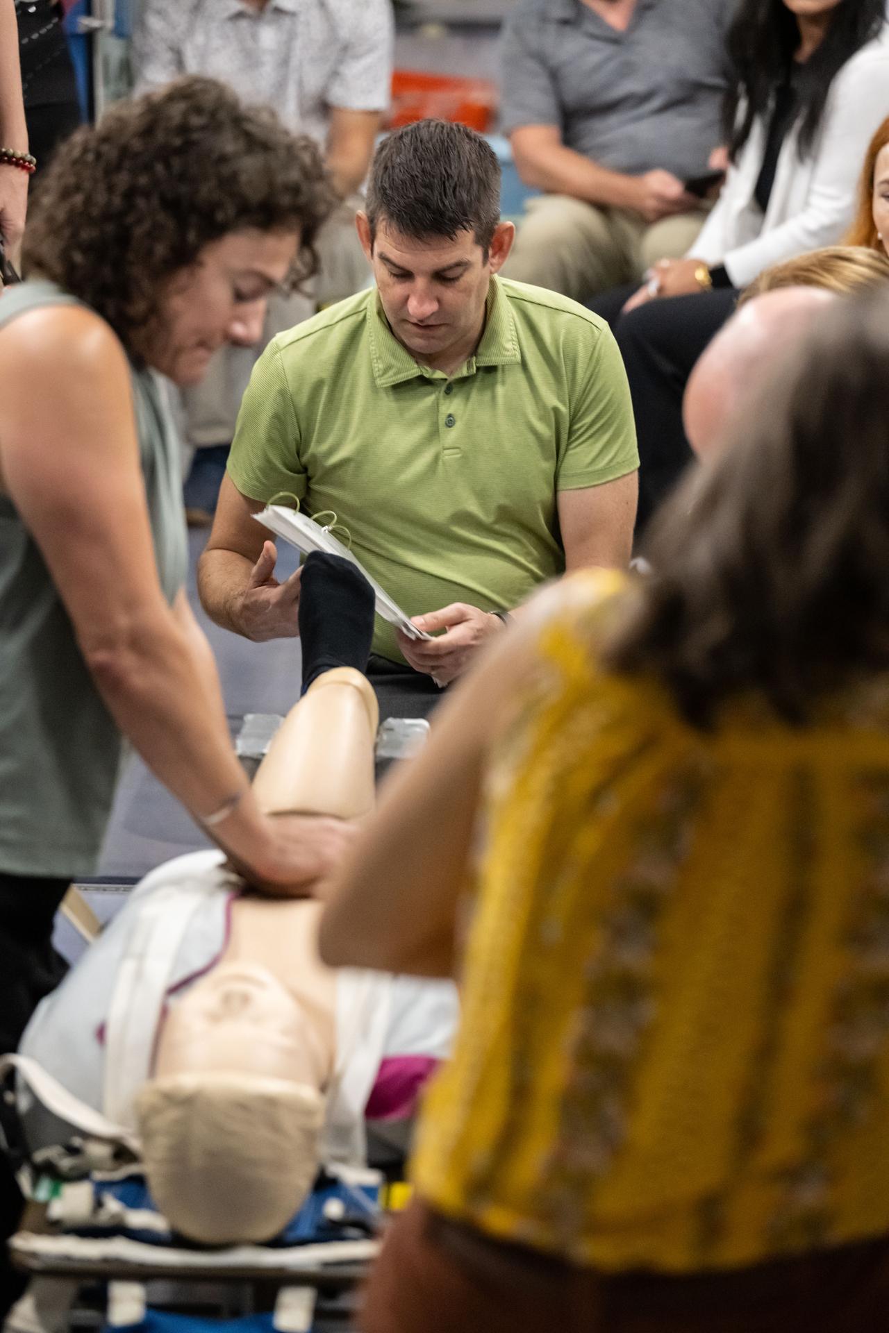 NASA's SpaceX Crew-12 members Jessica Meir and Jack Hathaway, both NASA astronauts, practice cardiopulmonary resuscitation (CPR) during a medical emergency simulation as part of their training for mission to the International Space Station. Surrounding Meir and Hathaway are various training support personnel at NASA's Johnson Space Center in Houston, Texas.