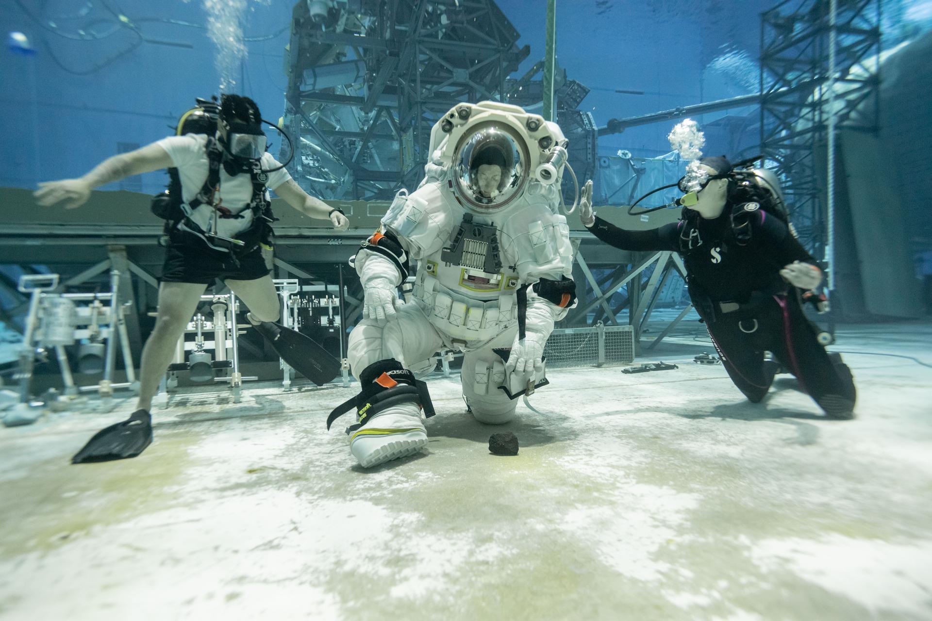 NASA astronaut Loral O’Hara kneels to pick up a rock while testing the mobility of Axiom Space’s lunar spacesuit. NASA and Axiom Space teams held the first dual spacesuit run at the Neutral Buoyancy Laboratory in Houston on September 24, 2025 with NASA Astronauts Stan Love and Loral O’Hara wearing Axiom Space’s lunar spacesuit, called the Axiom Extravehicular Mobility Unit (AxEMU). This was the final integration test in the pool, proving both the spacesuit and facility are prepped and ready for Artemis training.