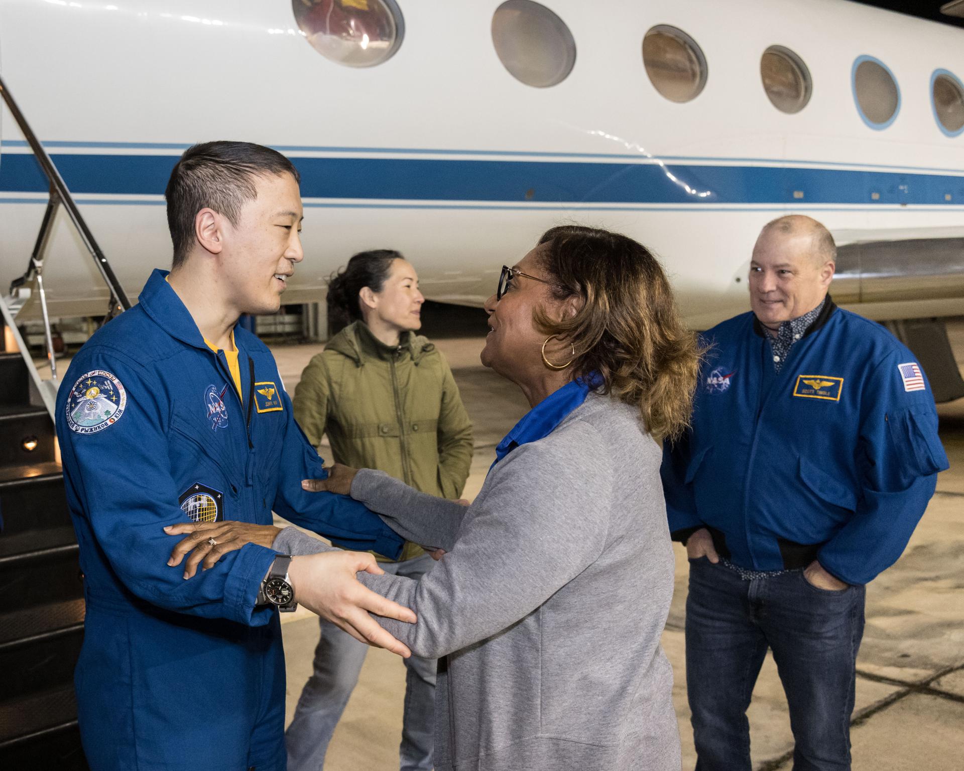 NASA astronaut Jonny Kim, greeted by Johnson Space Center Director Vanessa Wyche, is pictured at Ellington Field outside the Gulfstream V aircraft that returned him to Houston, Texas, from Kazakhstan in Central Asia. The day before, Kim had landed in Kazakhstan aboard the Soyuz MS-27 crew spacecraft with Roscosmos cosmonauts Sergey Ryzhikov and Alexey Zubritsky after completing a 245-day research mission aboard the International Space Station. In the background (from left), is a NASA employee and NASA astronaut and Chief of the Astronaut Scott Tingle.