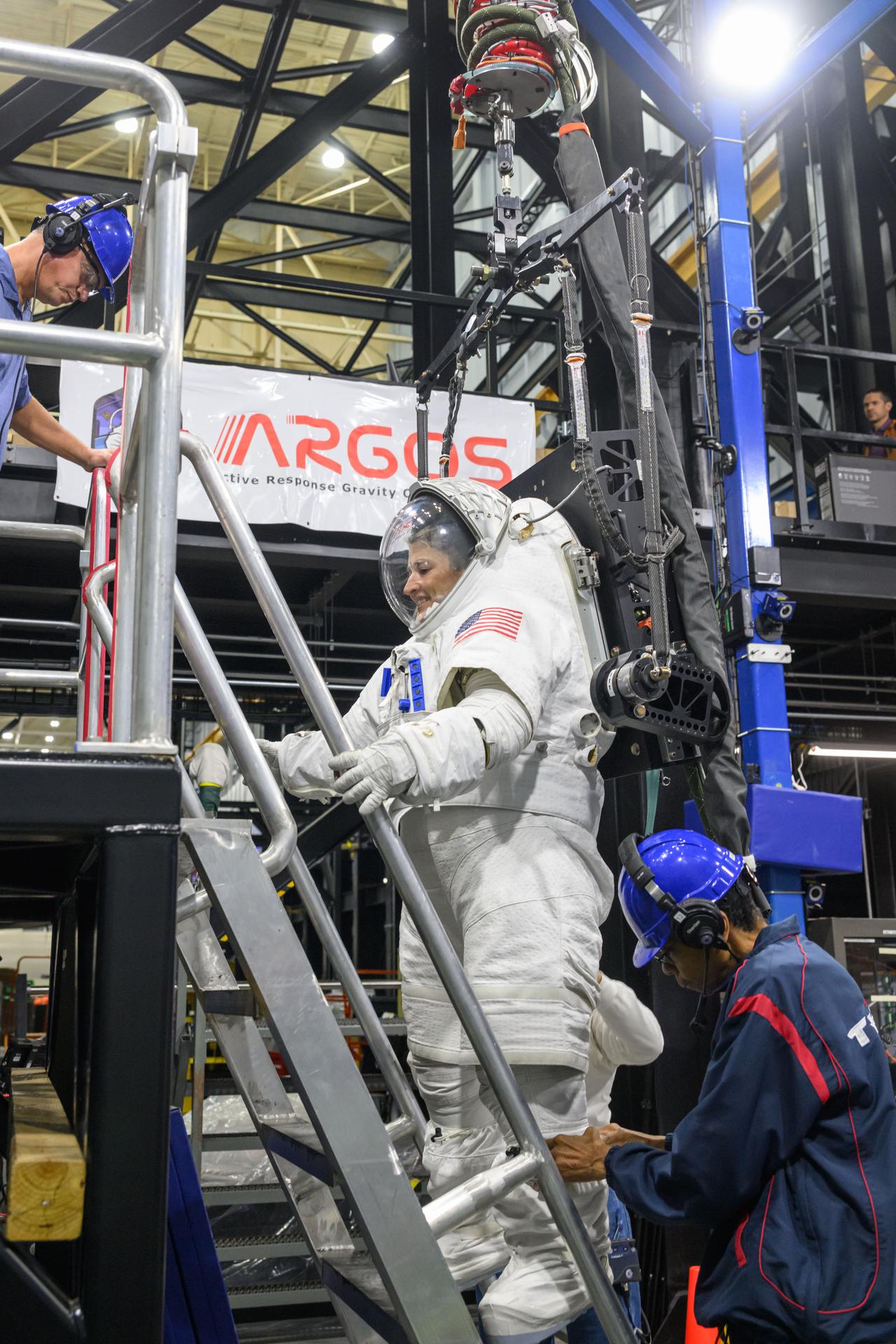 Artemis II astronaut Christina Koch climbs down the ladder of a mockup lander while wearing the xEMU spacesuit during the Artemis Spaceflight Standard Measures Test at NASA’s Johnson Space Center on Dec. 12, 2025.  (NASA/Helen Arase Vargas)