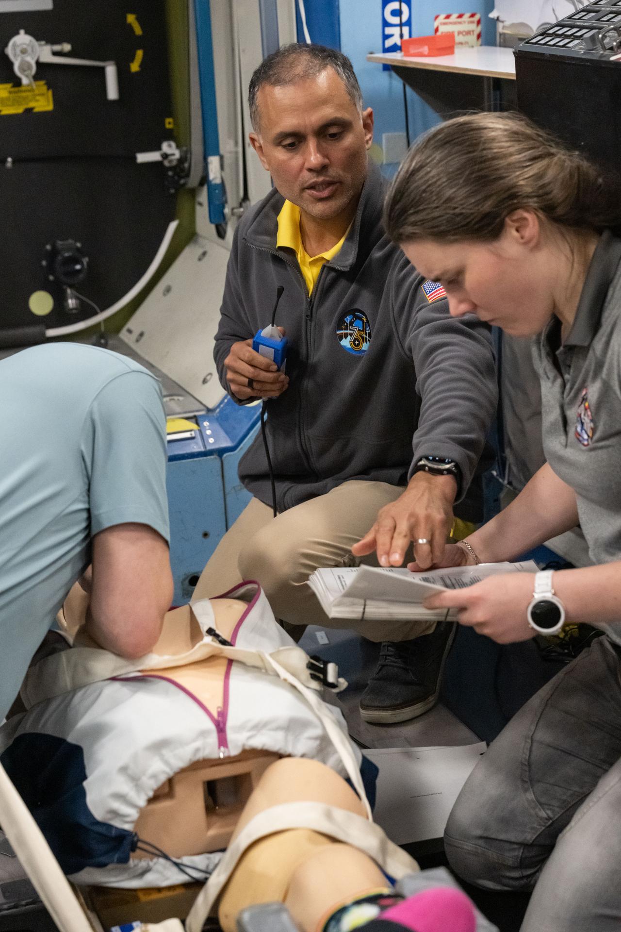 From left, Expedition 75 crew members Pyotr Dubrov, Anil Menon, and Anna Kikina participate in an emergency training session at Johnson Space Center's Space Vehicle Mockup Facility in Houston, Texas, ahead of their upcoming mission to the International Space Station.