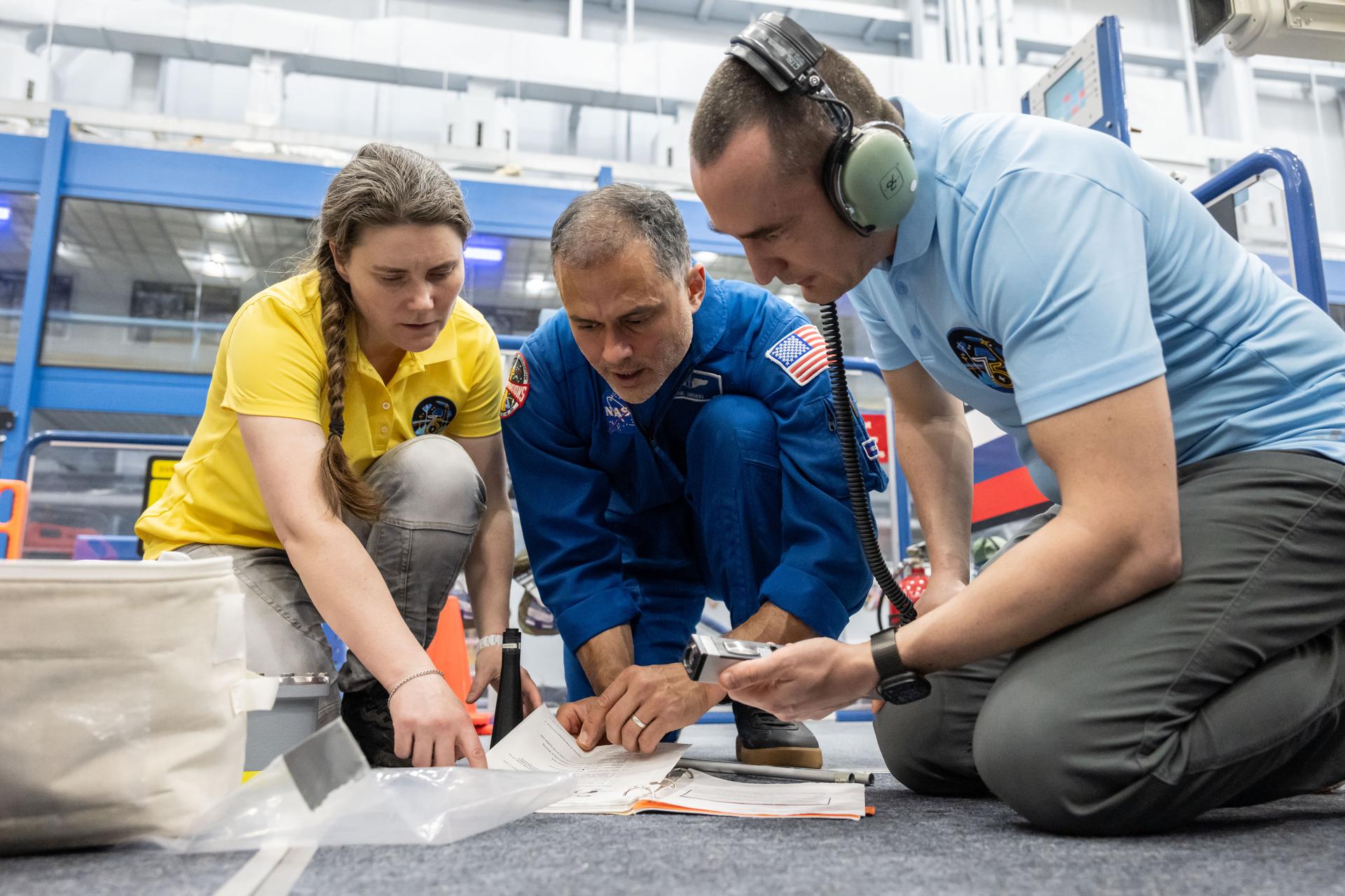 From left, Expedition 75 crew members Anna Kikina, Anil Menon, and Pyotr Dubrov participate in an emergency training session at Johnson Space Center's Space Vehicle Mockup Facility in Houston, Texas, ahead of their upcoming mission to the International Space Station.