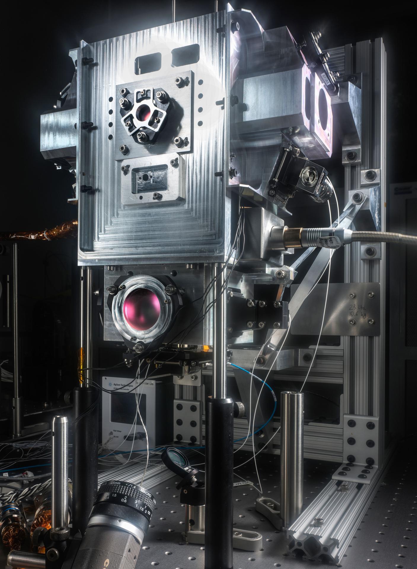 jsc2026e014318 (March 23, 2026) --- Preflight image of the SM-3X module as part of the Cold Atom Lab (CAL). NASA’s CAL hosts multiple experiments that explore the fundamental nature of atoms by cooling them down to nearly absolute zero (the coldest temperature matter can reach). The pink-colored coated mirrors on the front and sides reflect five sets of laser beams to pre-cool atoms before they are loaded into a magnetic trap. Radio frequencies from an internal antenna lower the temperature of the trapped atoms to the extreme cold needed to observe quantum phenomena. Credit: NASA/JPL-Caltech.