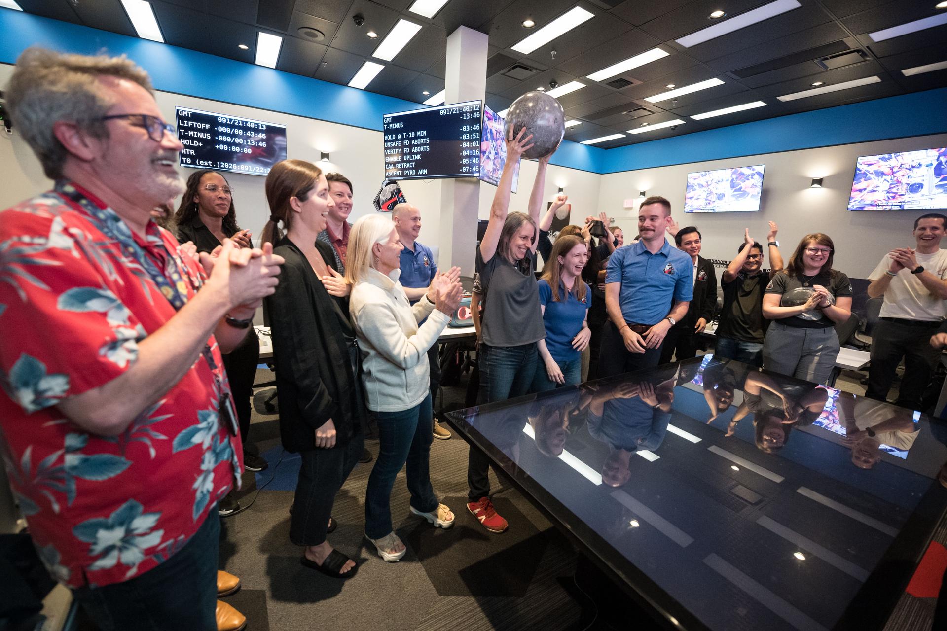 Members of the Artemis lunar science team cheer as they gather to watch the Artemis II launch broadcast from the Science Evaluation Room (SER) in Mission Control at NASA's Johnson Space Center in Houston. The SER supports lunar science and planetary observations for the Artemis science officer in the mission’s main flight control room. Built specifically for Artemis missions with these science priorities in mind, the SER is equipped to support rapid data interpretation, collaborative analysis, real-time decision making, and seamless coordination between the science and operations teams. Credits: NASA/Mark Sowa.