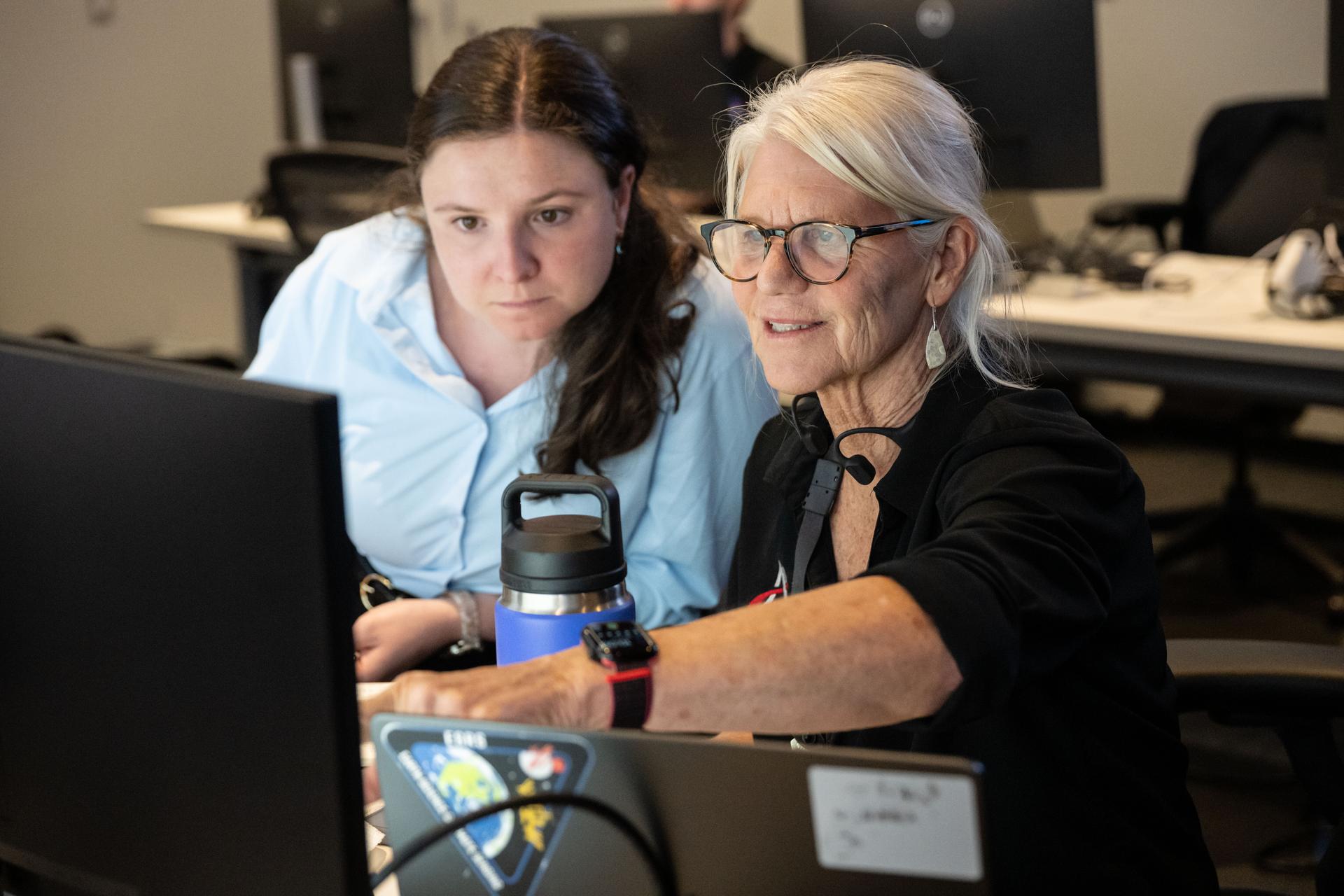 Artemis II lunar science team members, from left, Megan Borel, and Cindy Evans, discuss the lunar targeting plan for the astronauts' several-hour flyby of the Moon, scheduled for April 6. As they pass the Moon, the crew will apply geology skills learned in the classroom and in Moon-like environments on Earth to photograph and describe features including impact craters, ancient lava flows, and surface cracks and ridges formed as the Moon slowly changed over time. They will note differences in color, brightness, and texture, which provide clues that help scientists understand what the surface is made of and how it formed. Credits: NASA/Bill Stafford