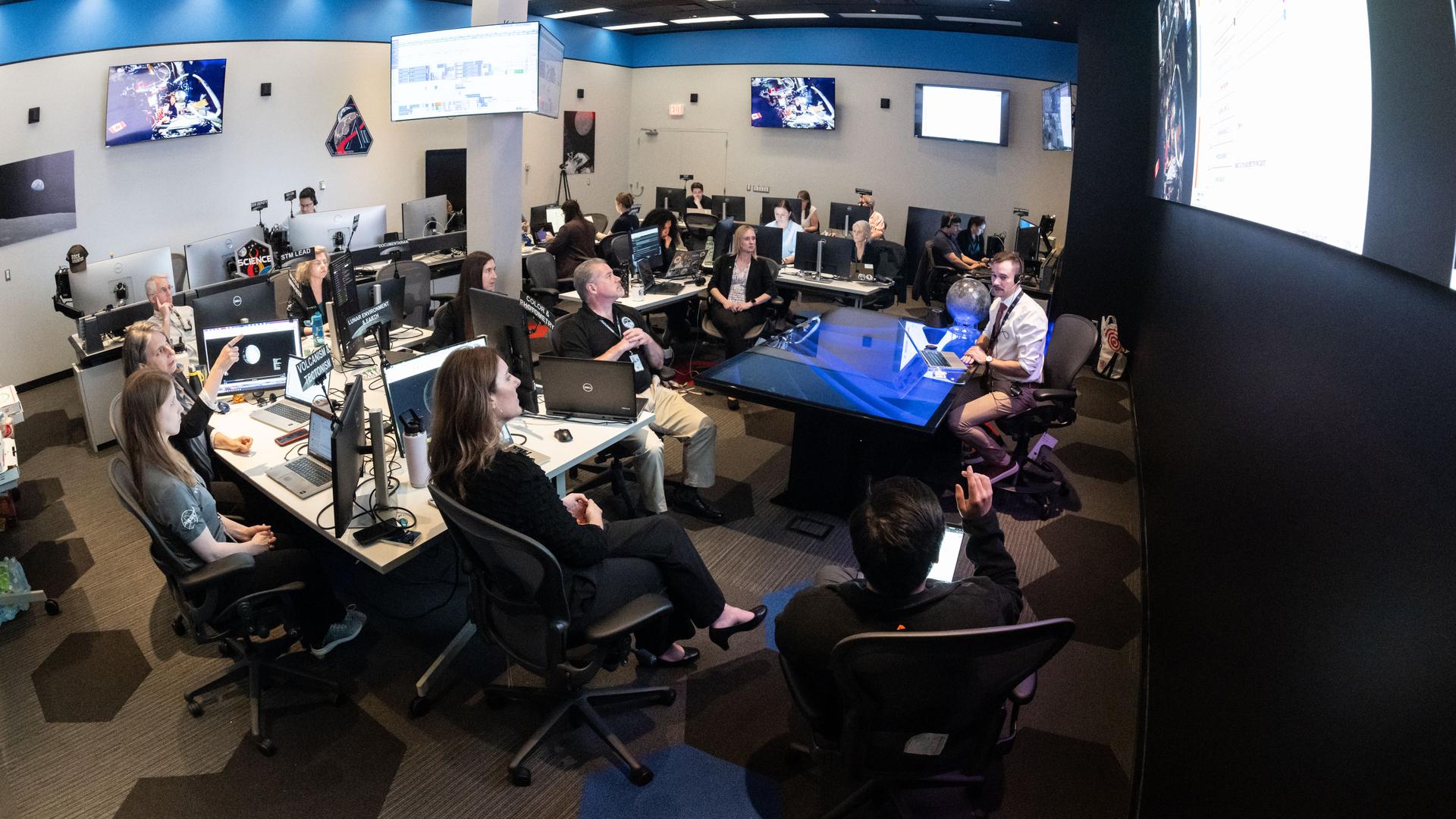 The Artemis II lunar science team works on the lunar targeting plan for the astronauts' several-hour flyby of the Moon, scheduled for April 6. As they pass the Moon, the crew will apply geology skills learned in the classroom and in Moon-like environments on Earth to photograph and describe features including impact craters, ancient lava flows, and surface cracks and ridges formed as the Moon slowly changed over time. They will note differences in color, brightness, and texture, which provide clues that help scientists understand what the surface is made of and how it formed. Credits: NASA/Bill Stafford