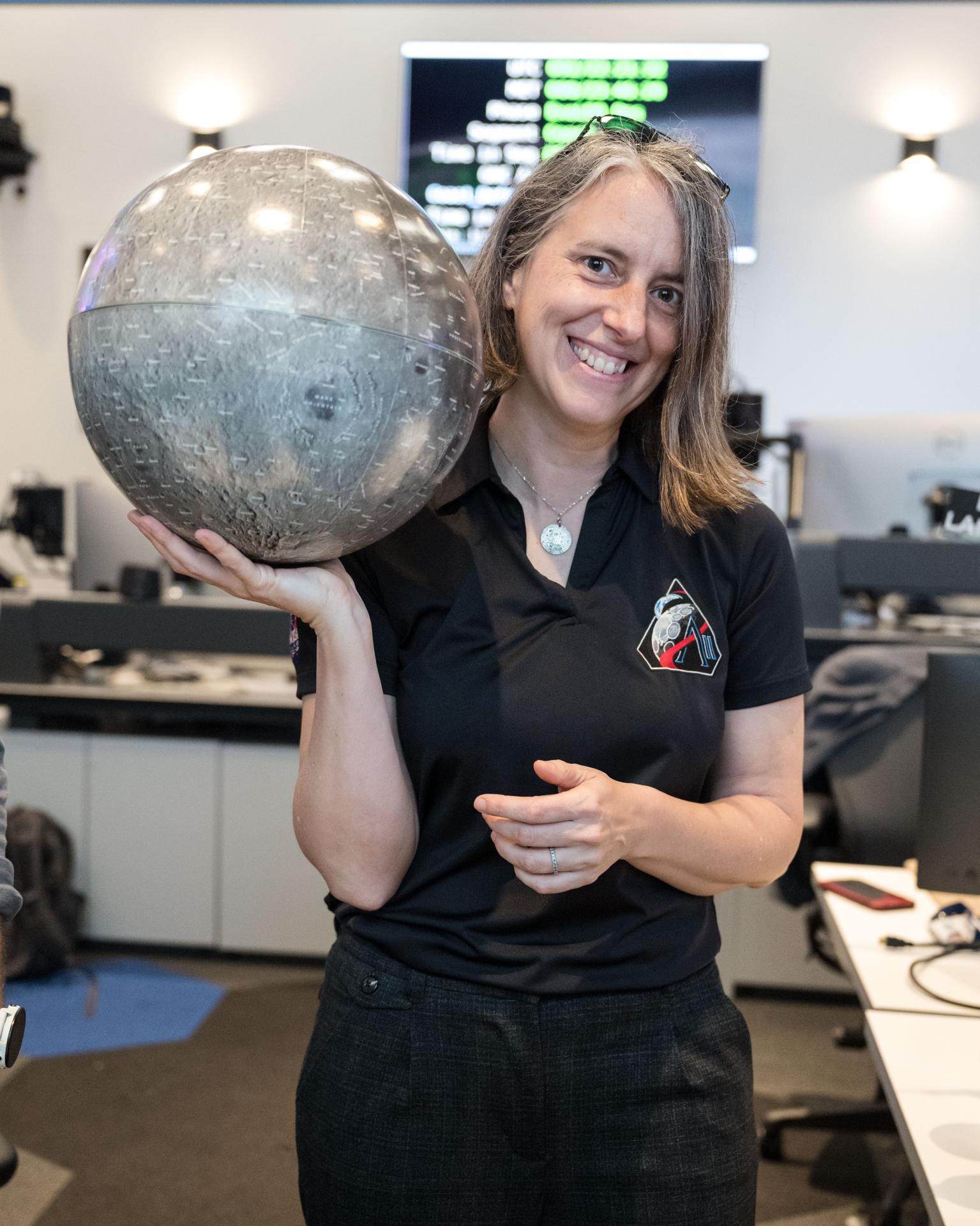 Artemis curation lead, Juliane Gross, holds a lunar globe in the Science Evaluation Room (SER) in Mission Control at Johnson Space Center in Houston. The SER supports lunar science and planetary observations for the Artemis science officer in the mission’s main flight control room. Built specifically for Artemis missions with these science priorities in mind, the SER is equipped to support rapid data interpretation, collaborative analysis, real-time decision making, and seamless coordination between the science and operations teams. Credits: NASA/Luna Posadas Nava