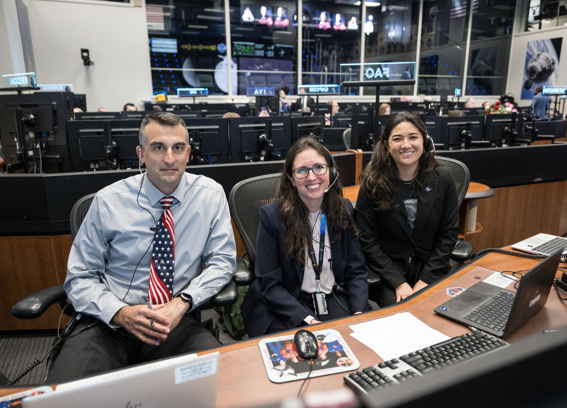 Artemis II science officers, from left, Trevor Graff, Kelsey Young, and Angela Garcia, are seen at the Science console in the White Flight Control Room in Mission Control at NASA's Johnson Space Center in Houston. Science officers are the senior flight controllers responsible for lunar science and geology objectives during Artemis missions. Credits: NASA/Robert Markowitz
