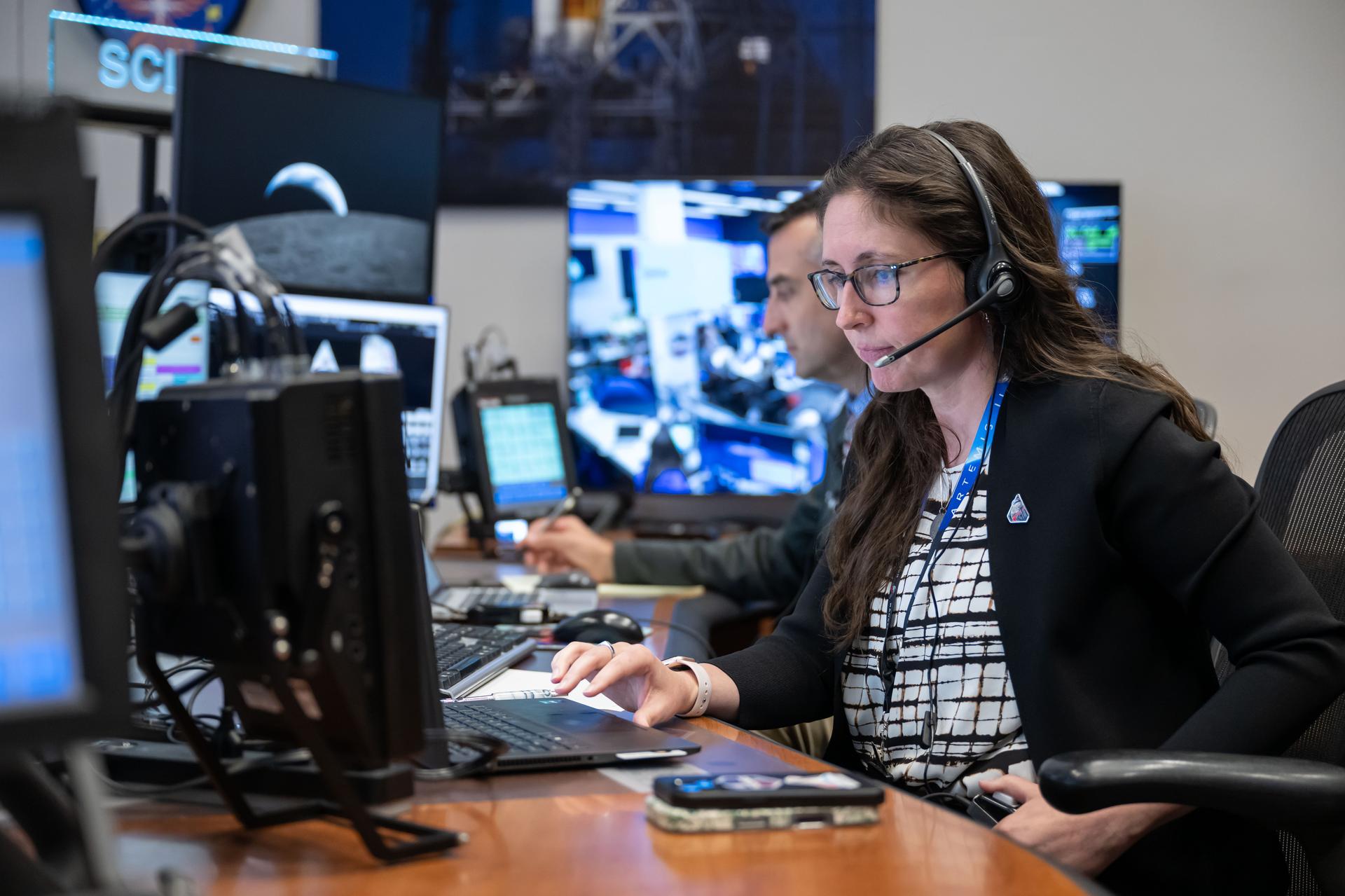 Artemis II science officers, Trevor Graff, background, and Kelsey Young are seen monitoring mission data in real-time from the Science console in the White Flight Control Room in Mission Control at NASA's Johnson Space Center in Houston. Science officers are the senior flight controllers responsible for lunar science and geology objectives during Artemis missions. Credits: NASA/Robert Markowitz