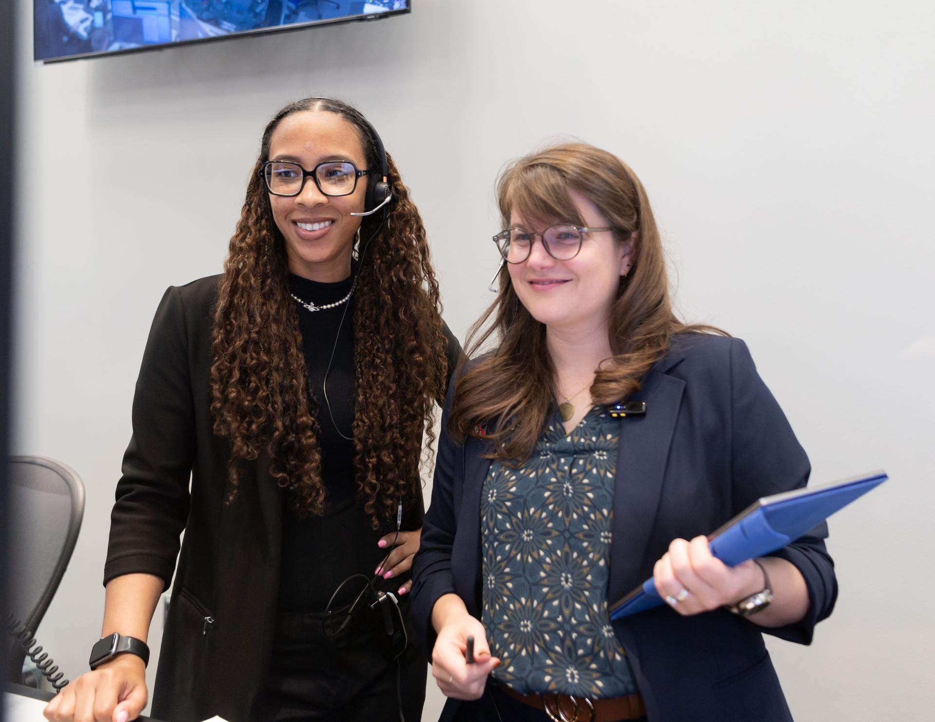 Science evaluation room communicator, Kiarre Dumes, left, and deputy lunar science lead Marie Henderson work in the Science Evaluation Room (SER) during Artemis II. Built specifically for Artemis missions with these science priorities in mind, the SER is equipped to support rapid data interpretation, collaborative analysis, real-time decision making, and seamless coordination between the science and operations teams. Credits: NASA/Luna Posadas Nava