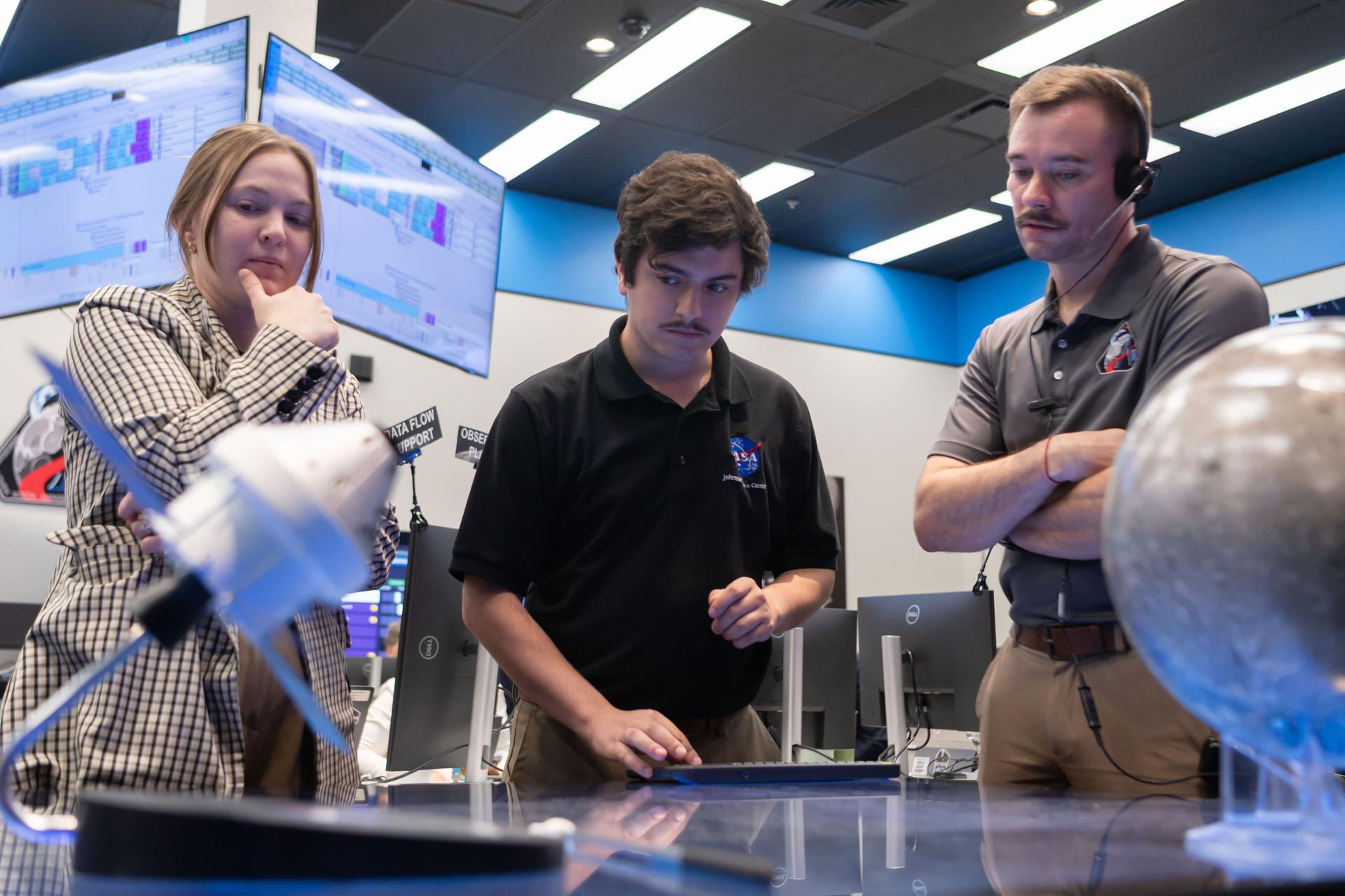 Crew lunar observations team member, Sara Schmidt, left, asset manager, Luke McSherry, and Artemis deputy lunar science lead, Jacob Richardson work in the Science Evaluation Room (SER). Built specifically for Artemis missions with these science priorities in mind, the SER is equipped to support rapid data interpretation, collaborative analysis, real-time decision making, and seamless coordination between the science and operations teams. Credits: NASA/Luna Posadas Nava