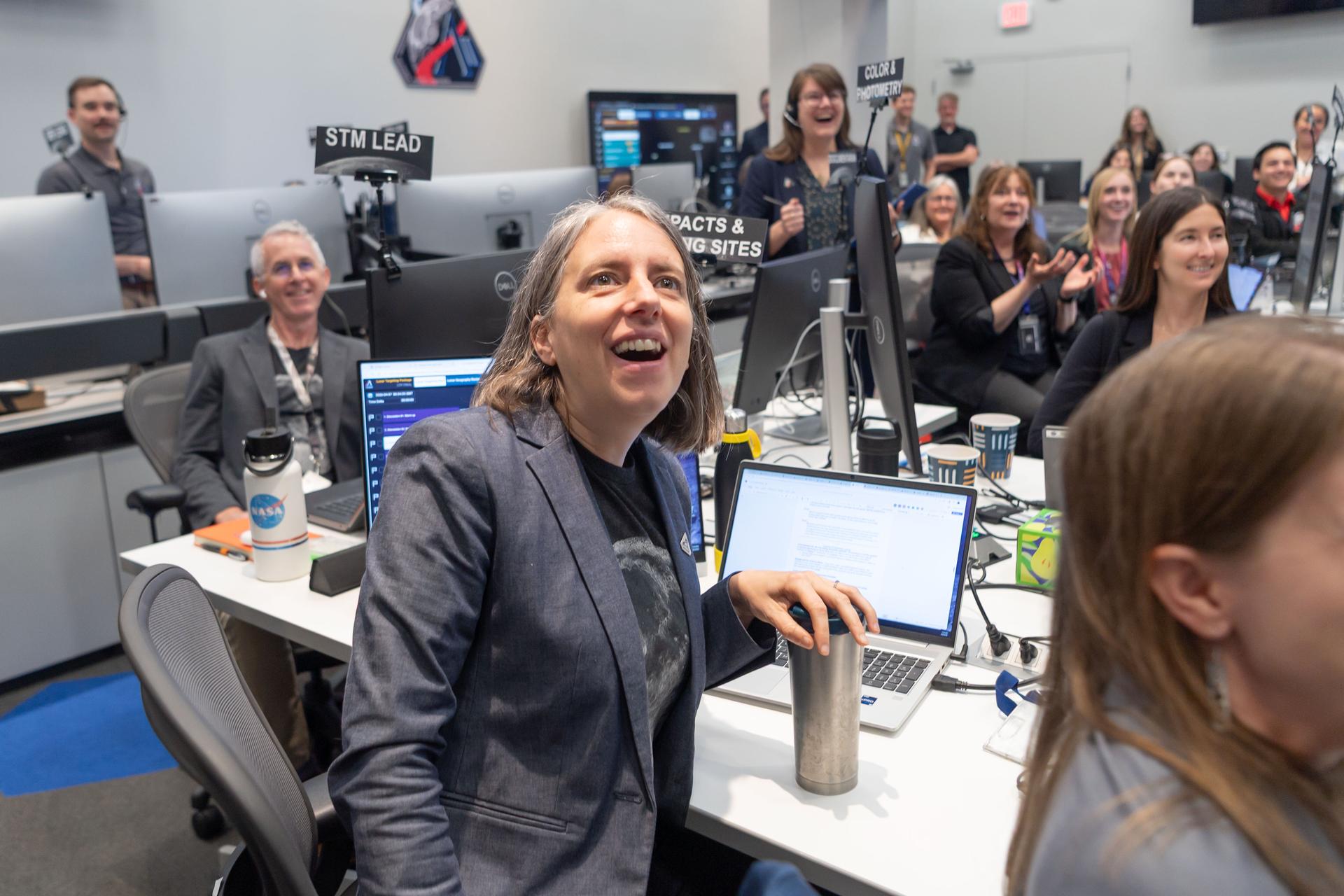 Artemis II lunar science team member, Juliane Gross, center, and the extended lunar science team behind her, celebrates crew observations made during the lunar flyby on April 6. The team worked in the Science Evaluation Room (SER) in Mission Control at NASA’s Johnson Space Center in Houston. Built specifically for Artemis missions with these science priorities in mind, the SER is equipped to support rapid data interpretation, collaborative analysis, real-time decision making, and seamless coordination between the science and operations teams. Credits: NASA/Luna Posadas Nava