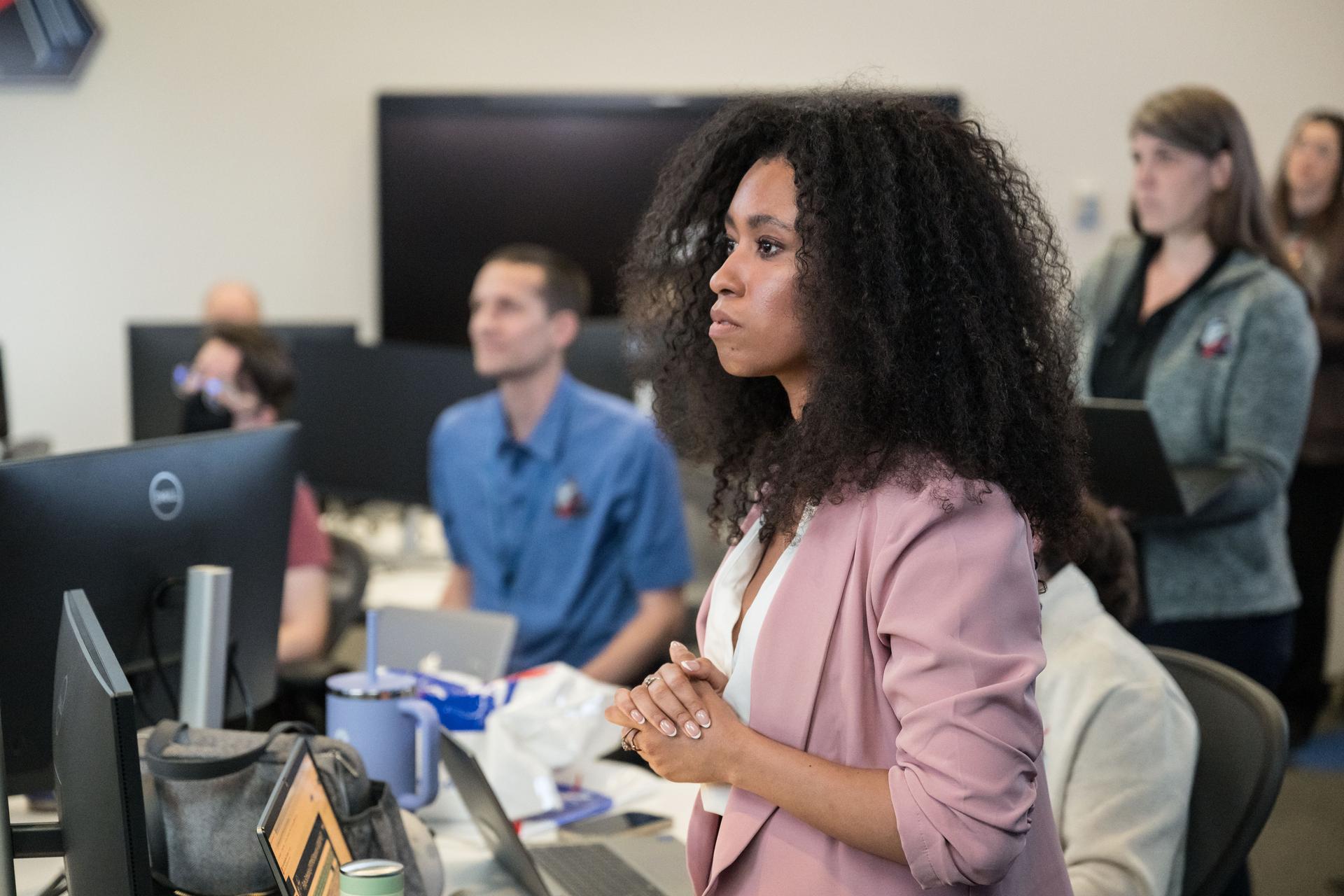Artemis II lunar science team member, foreground, Amber Turner, and David Hollibaugh-Baker, and Cherie Achilles, background, participate in the team’s analysis of crew observations during the lunar flyby on April 6, 2026. The team worked in the Science Evaluation Room (SER) in Mission Control at NASA’s Johnson Space Center in Houston. Built specifically for Artemis missions with these science priorities in mind, the SER is equipped to support rapid data interpretation, collaborative analysis, real-time decision making, and seamless coordination between the science and operations teams. Credits: NASA/ Robert Markowitz