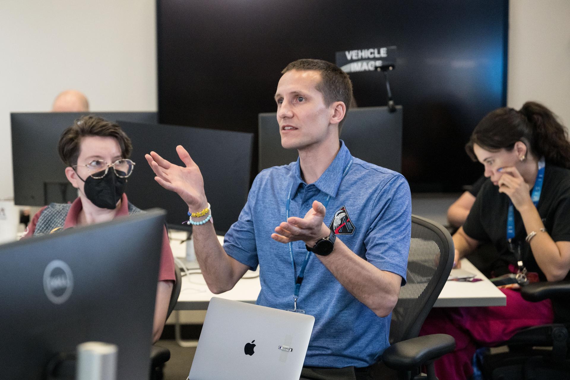 Artemis II lunar science team members, from left, Alexadra Constantinou, David Hollibaugh-Baker, participate in the team’s final preparations for the lunar flyby. NASA Johnson public affairs officer, Victoria Segovia, is seen in the background. The team worked in the Science Evaluation Room (SER) in Mission Control at NASA’s Johnson Space Center in Houston. Built specifically for Artemis missions with these science priorities in mind, the SER is equipped to support rapid data interpretation, collaborative analysis, real-time decision making, and seamless coordination between the science and operations teams. Credits: Credits: NASA/ Robert Markowitz