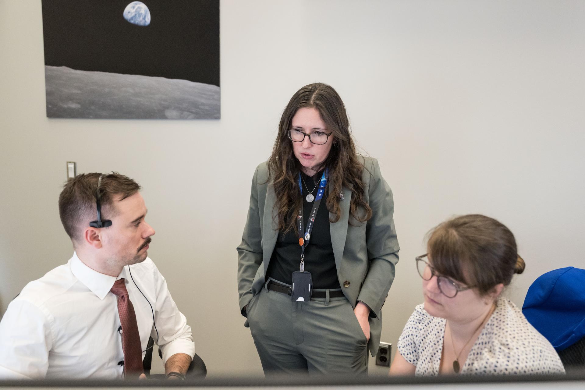 From left, Artemis II deputy lunar science lead, Jacob Richardson, science officer and lunar science lead, Kelsey Young, and deputy lunar science lead, Marie Henderson, discuss the team’s final preparations for the lunar flyby.  The team worked in the Science Evaluation Room (SER) in Mission Control at NASA’s Johnson Space Center in Houston. Built specifically for Artemis missions with these science priorities in mind, the SER is equipped to support rapid data interpretation, collaborative analysis, real-time decision making, and seamless coordination between the science and operations teams. Credits: NASA/ Robert Markowitz